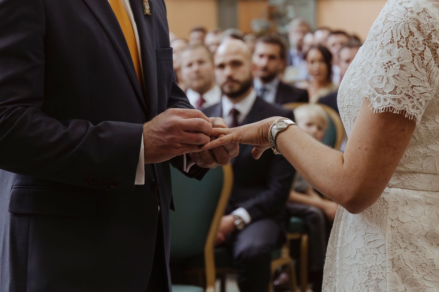 groom putting on th bride's wedding ring- up close detail shot