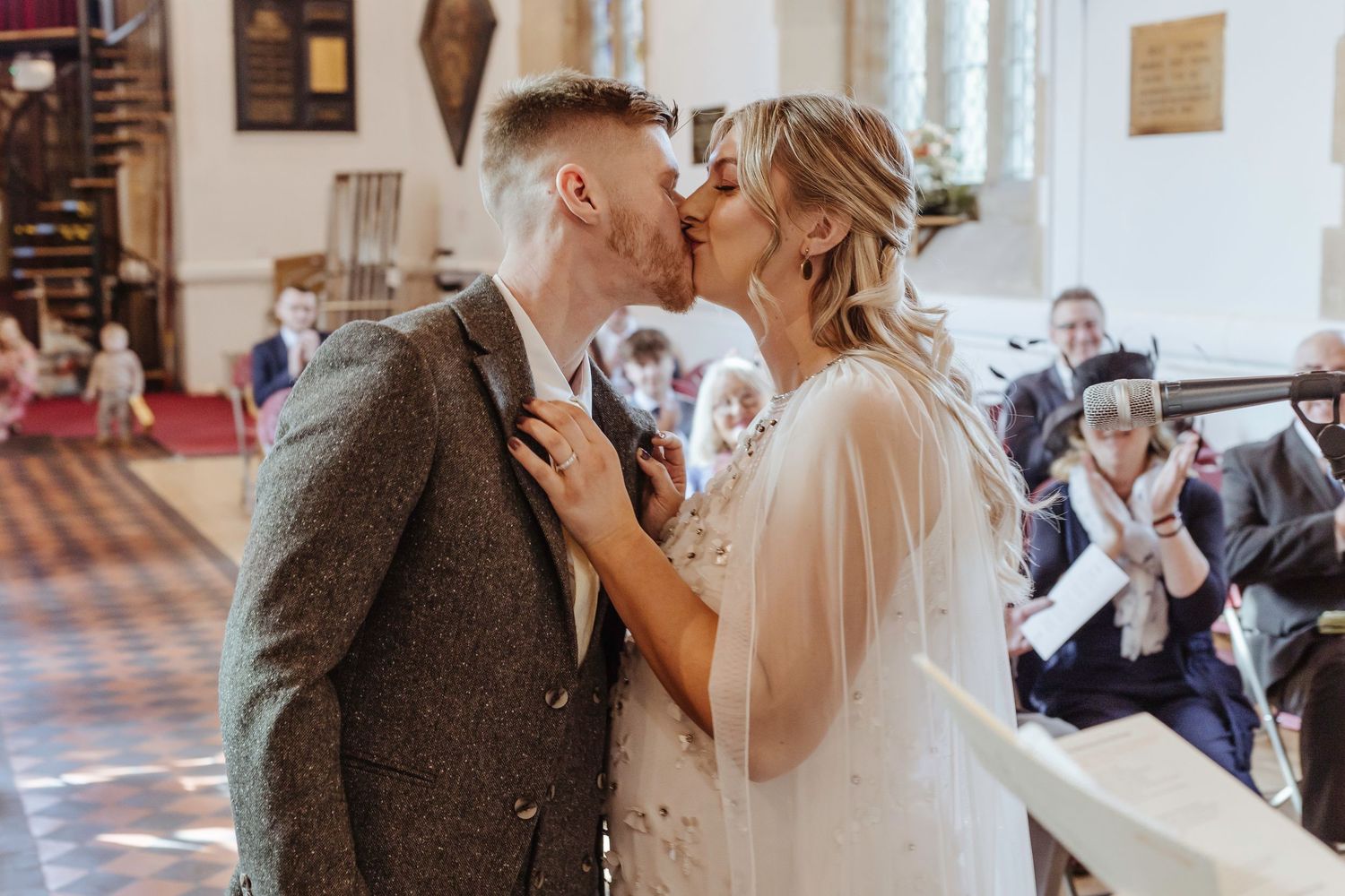bride and groom kissing at their wedding ceremony in the church