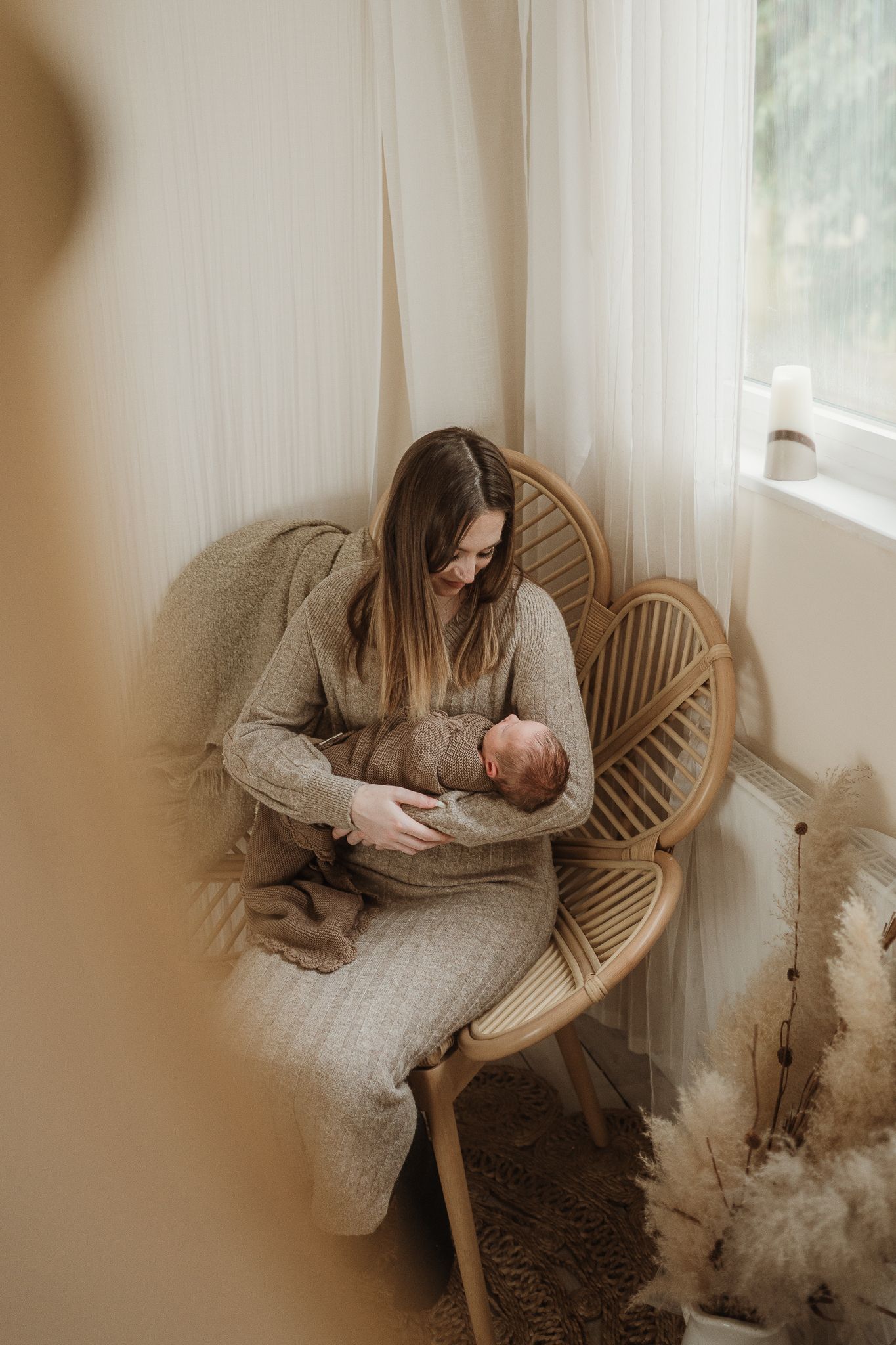 mother cradling newborn in chair