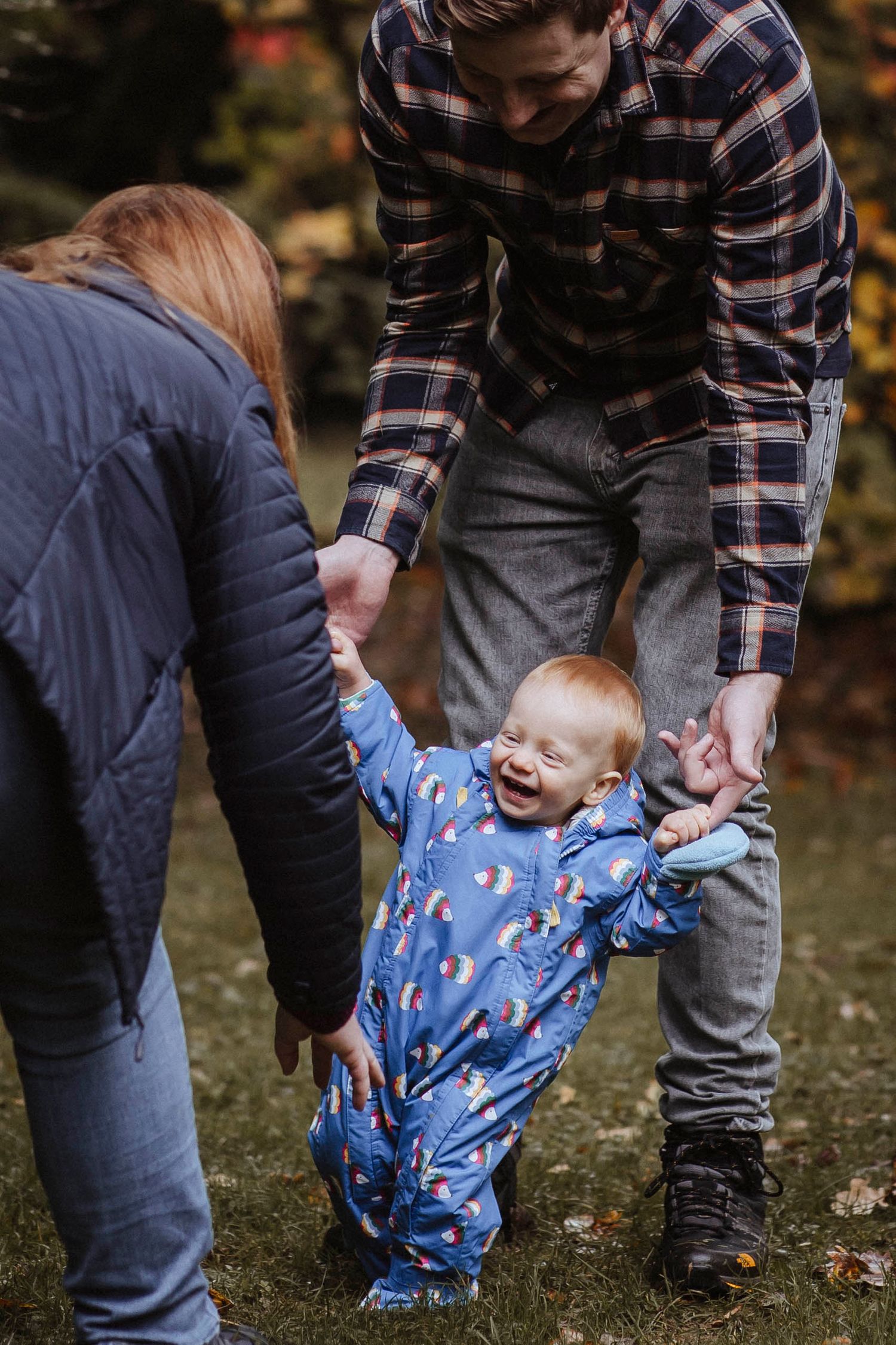 toddler walking holding hands with father towards his mother