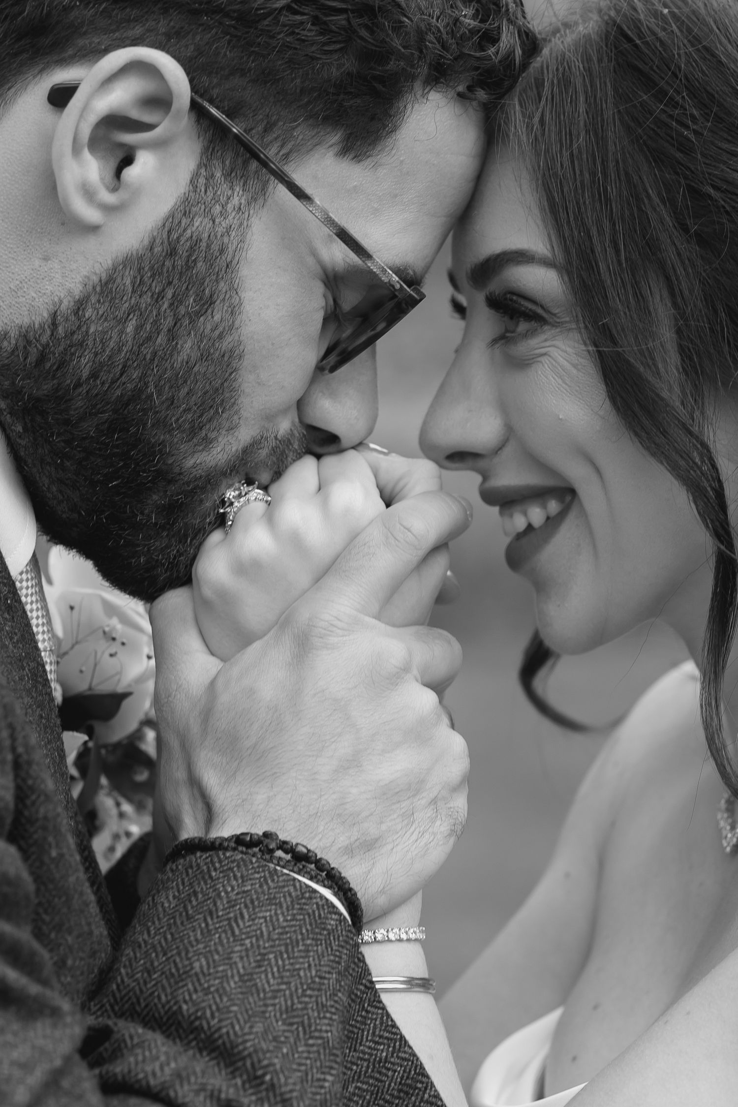 groom kissing his brides hands whilst holding them