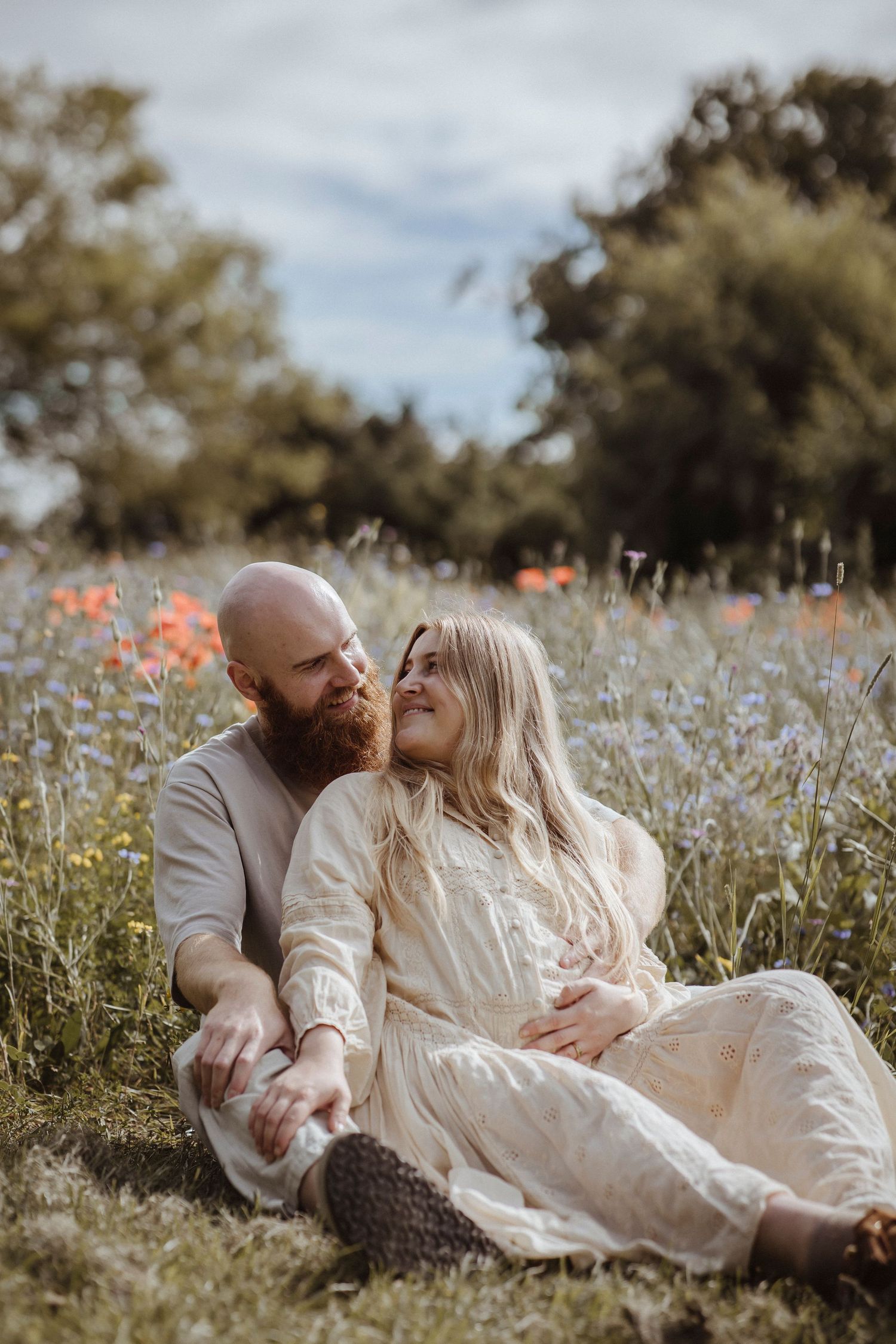 Soft light, wildflowers, and two hearts waiting for one more to join their little forever.
