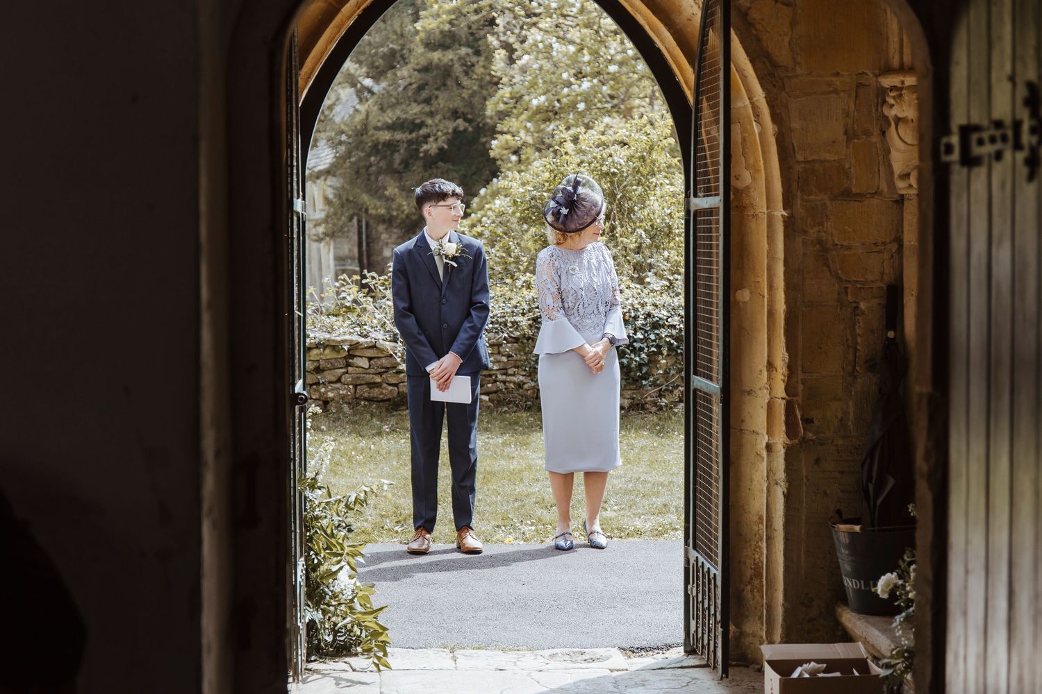 wedding guests stood outside the church greeting other guests