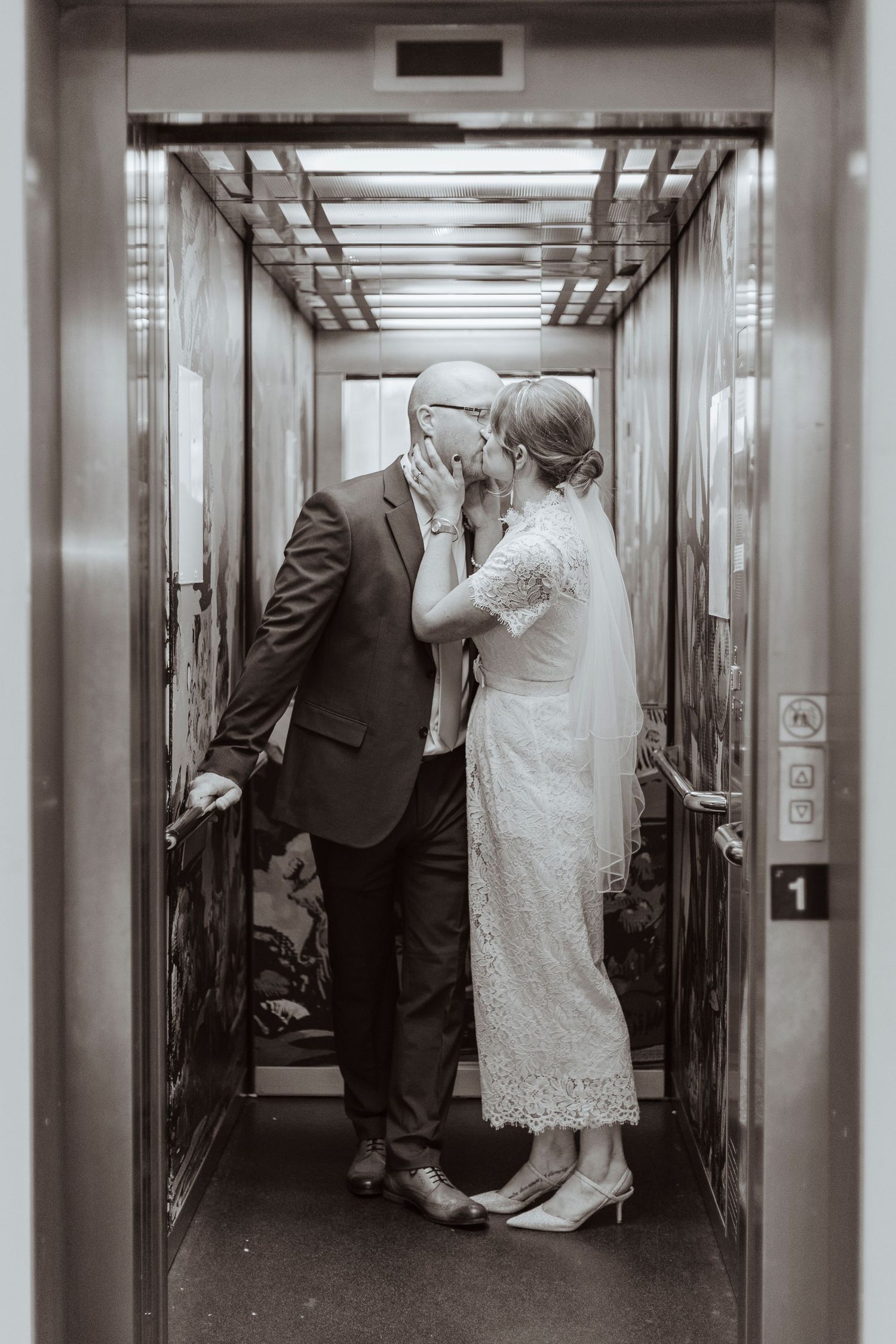 bride and groom sharing a kiss in a lift
