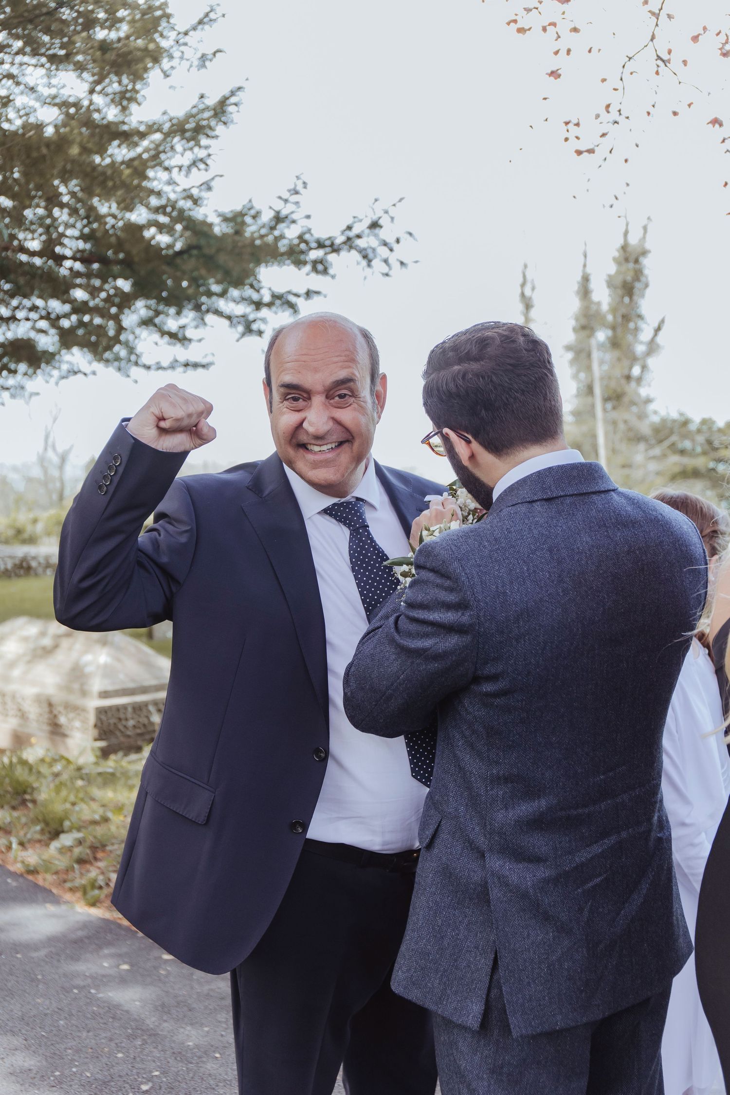 father of the groom cheering before the wedding ceremony as he gets his lapel fitted