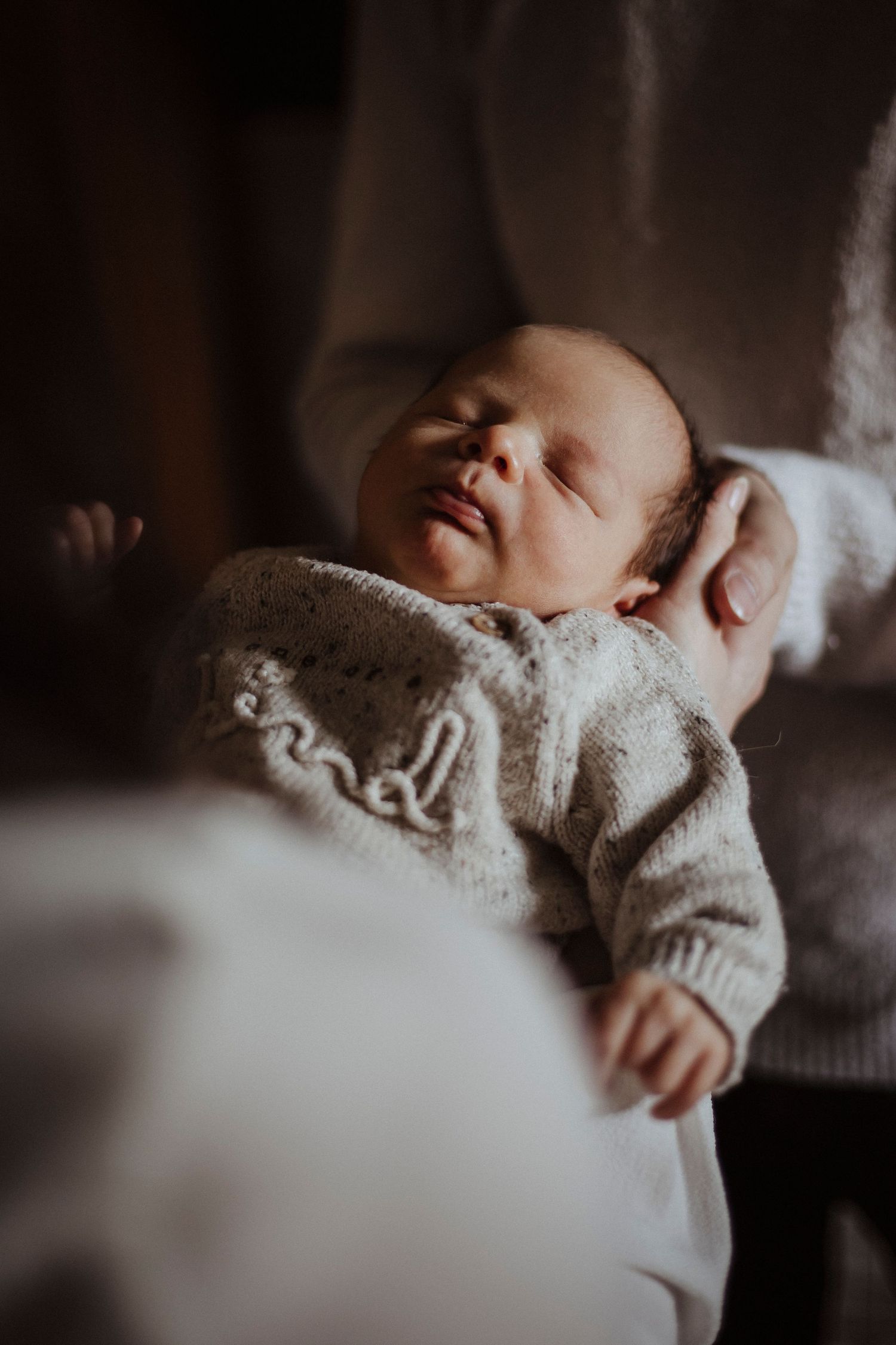 mother and father holding their sleeping baby