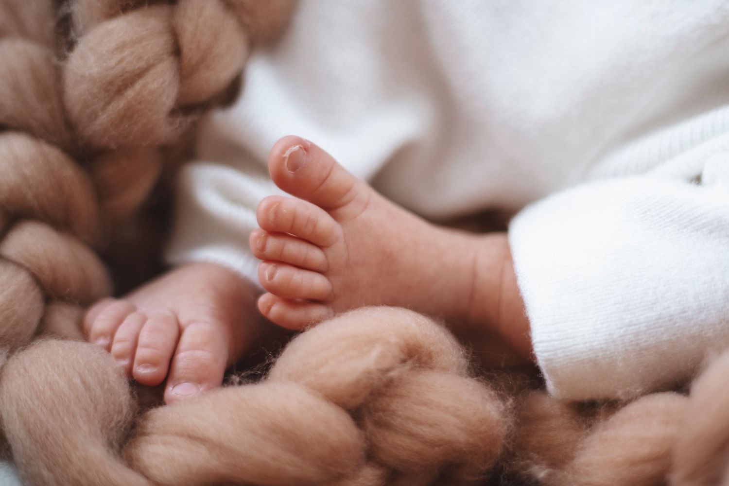 newborns feet on a knitted blanket