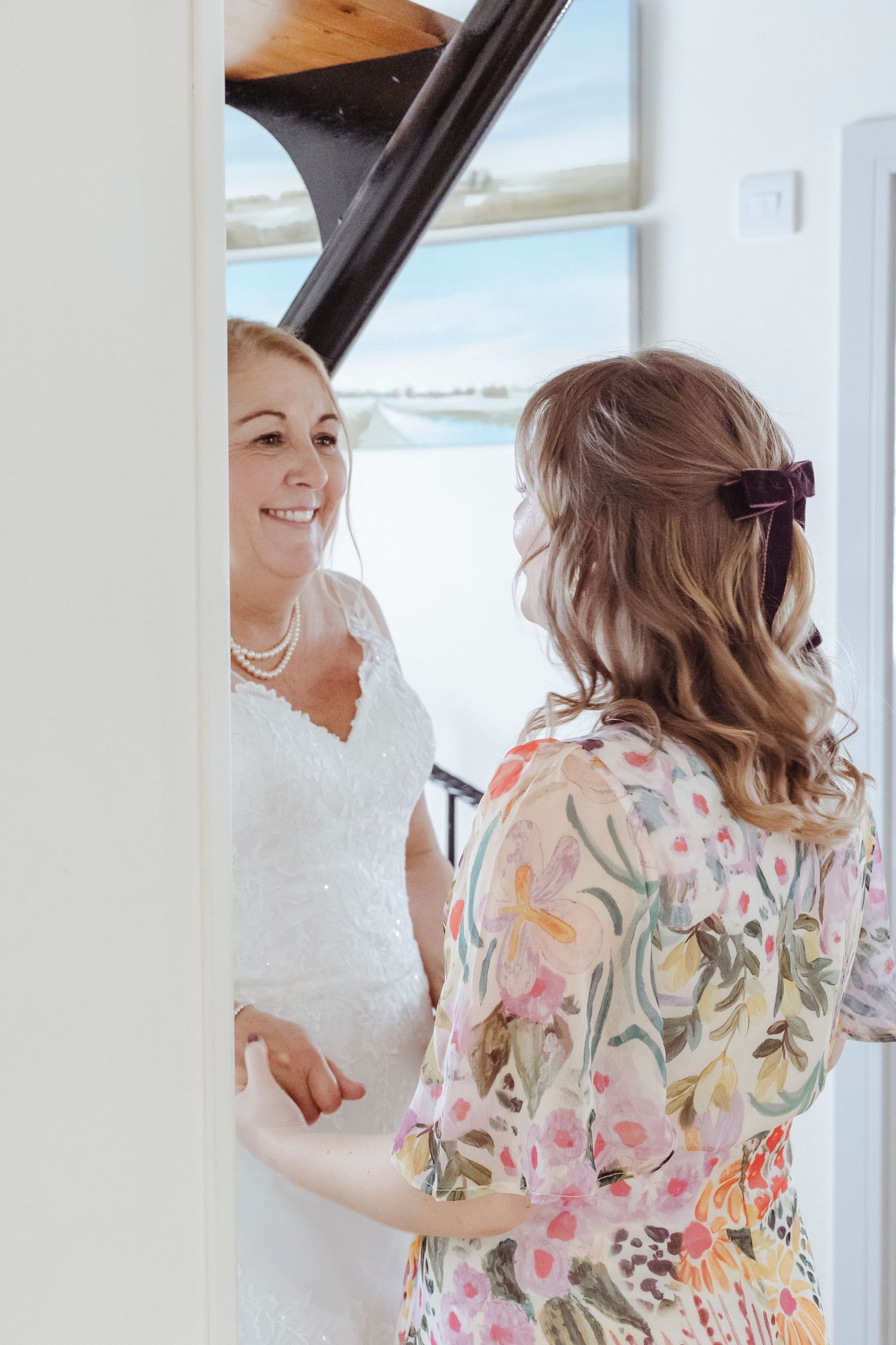 A sweet, supportive moment as the bride shares a warm smile with someone special before the ceremony.