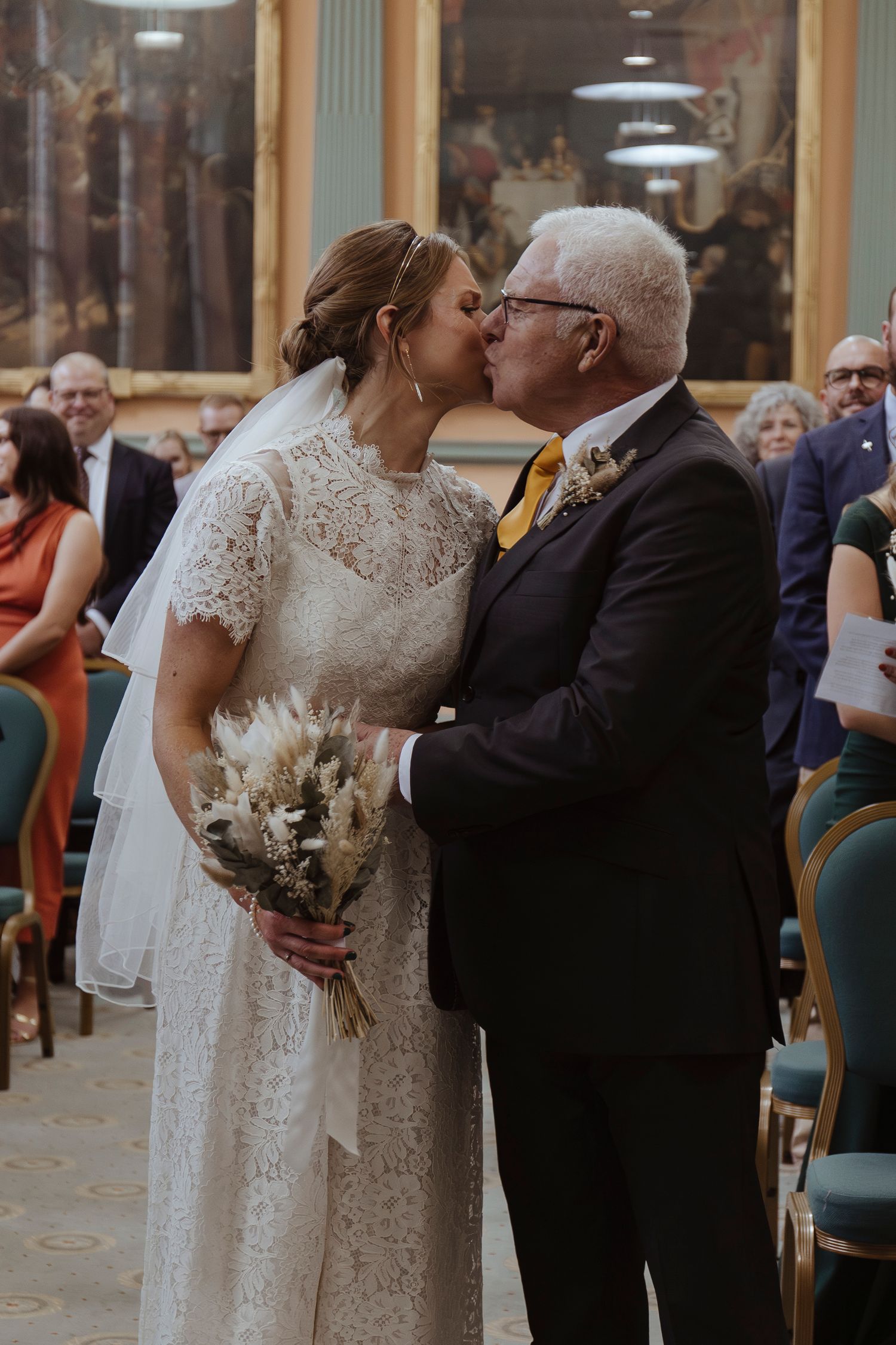 bride kissing father on cheek after walking her down the aisle