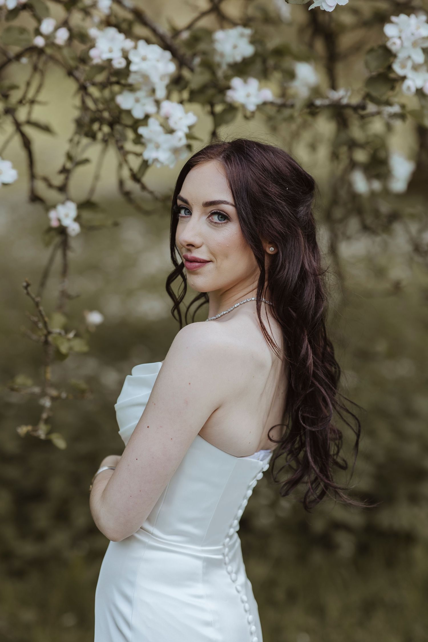 bride smiling look out in front of a blossom tree
