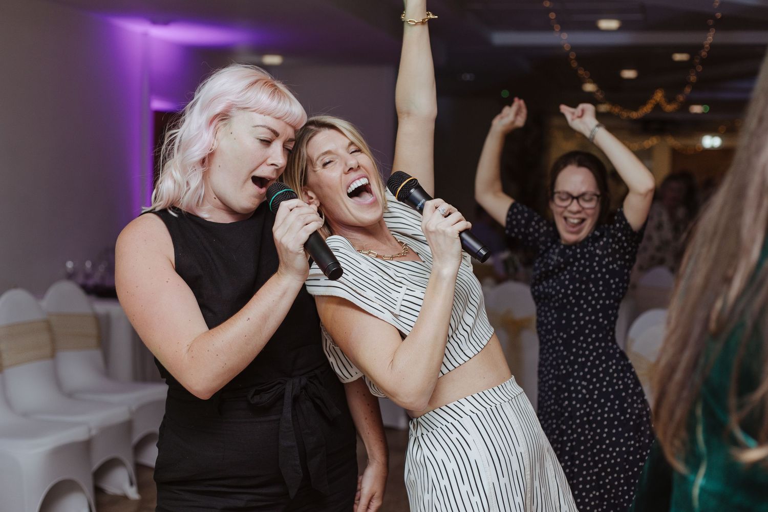 wedding guests dancing and singing holding microphones