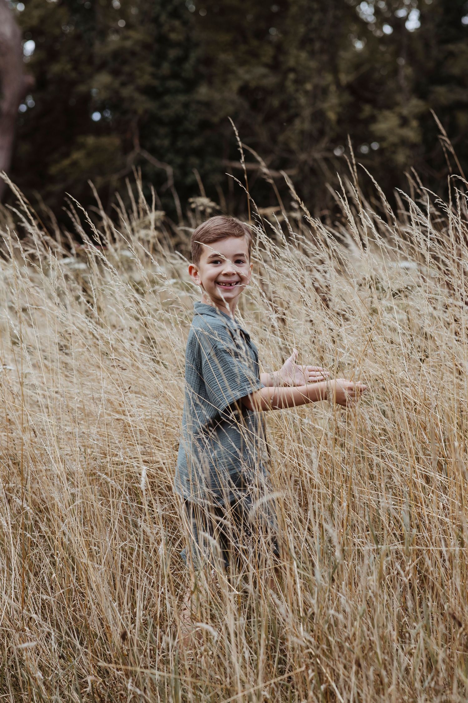 boy looking back and smiling in the long grass