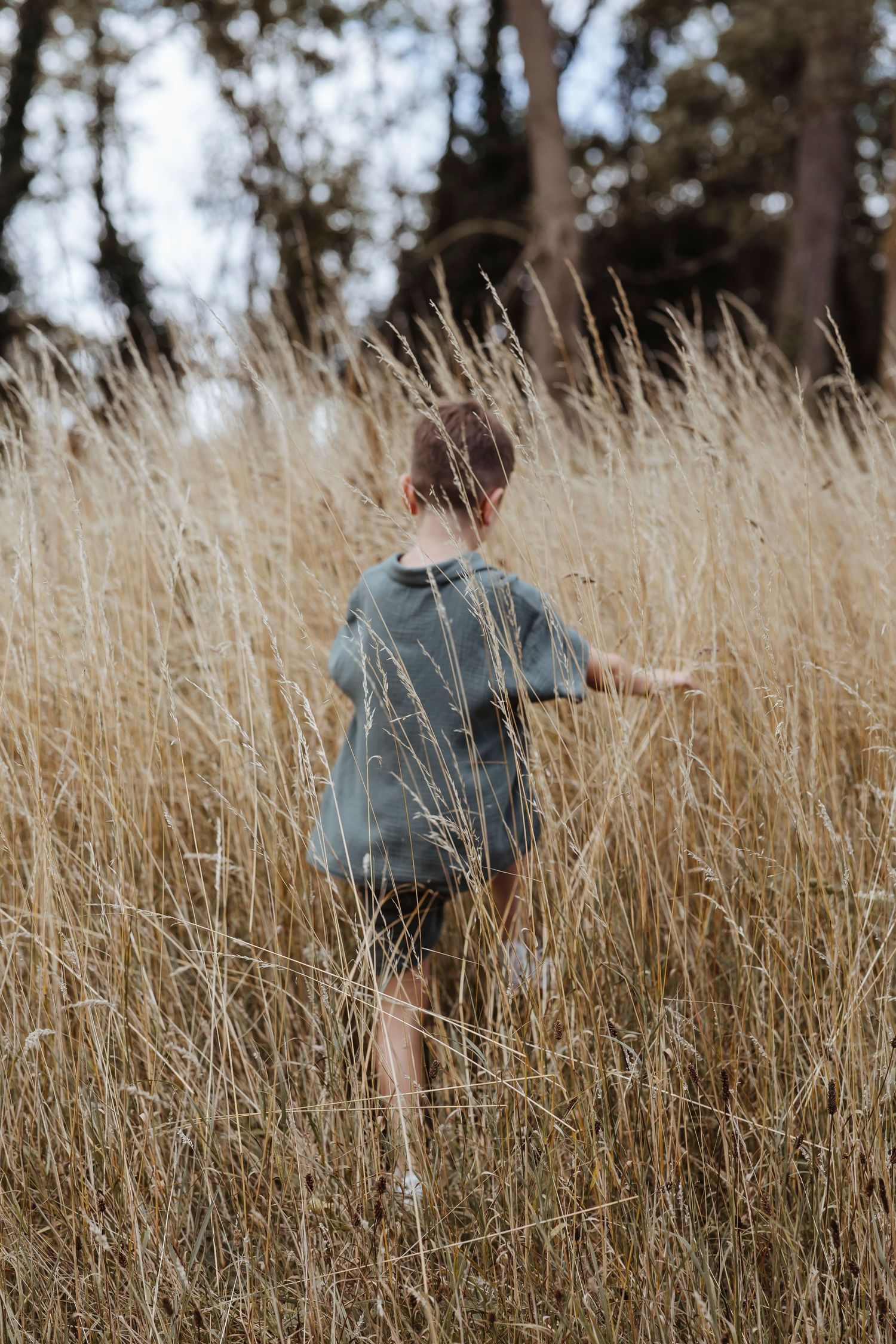 boy running through long grass