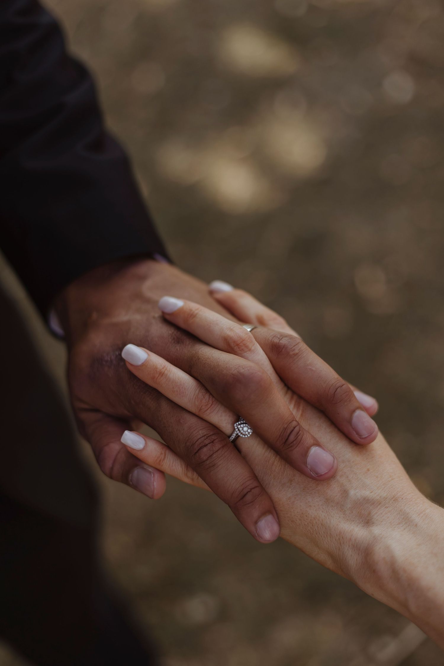 close up detail shots of the couples wedding rings whilst they hold hands and interlock fingers