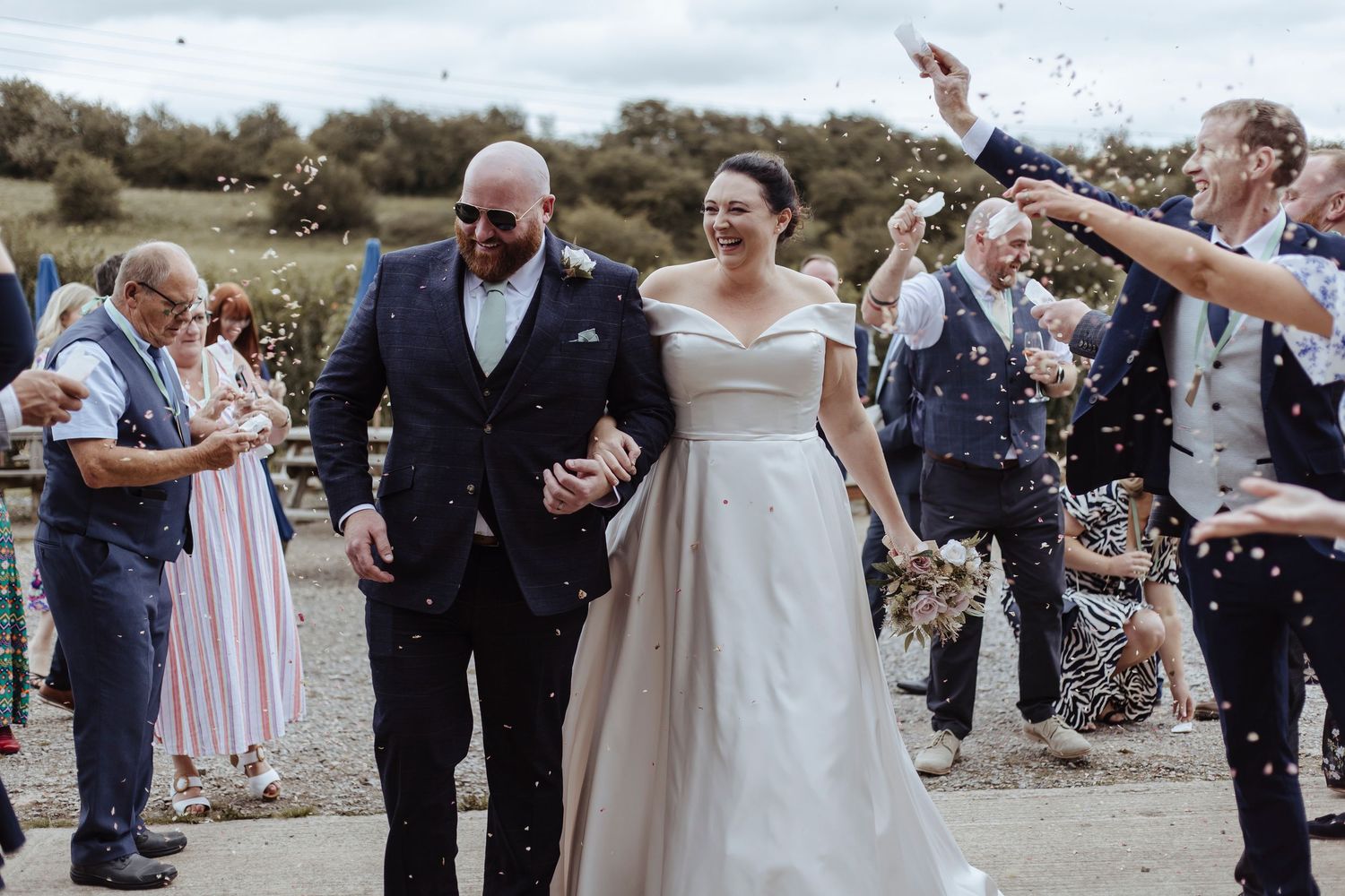 friends and family throwing confetti over the newlywed couple