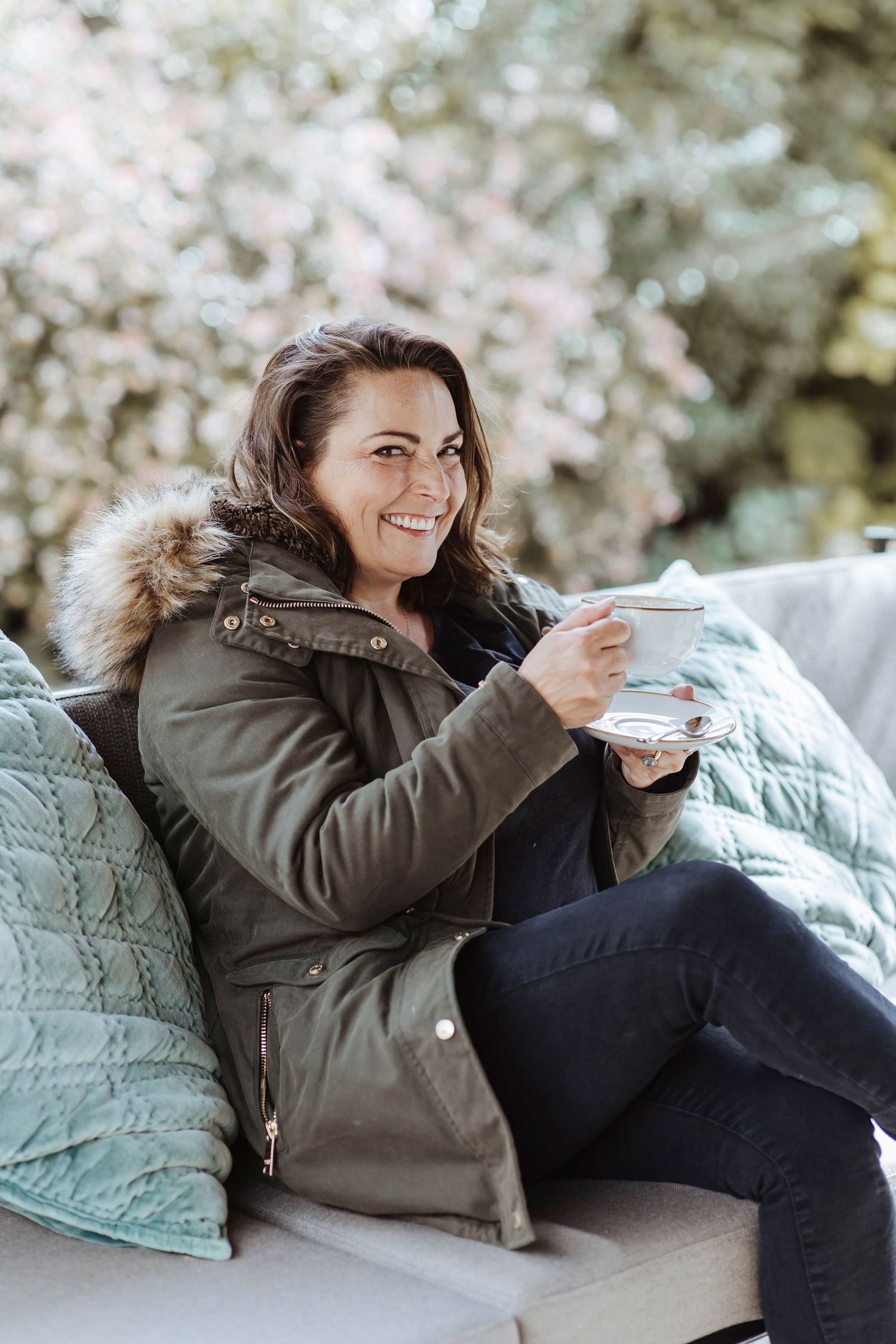 woman smiling holding a cup of coffee