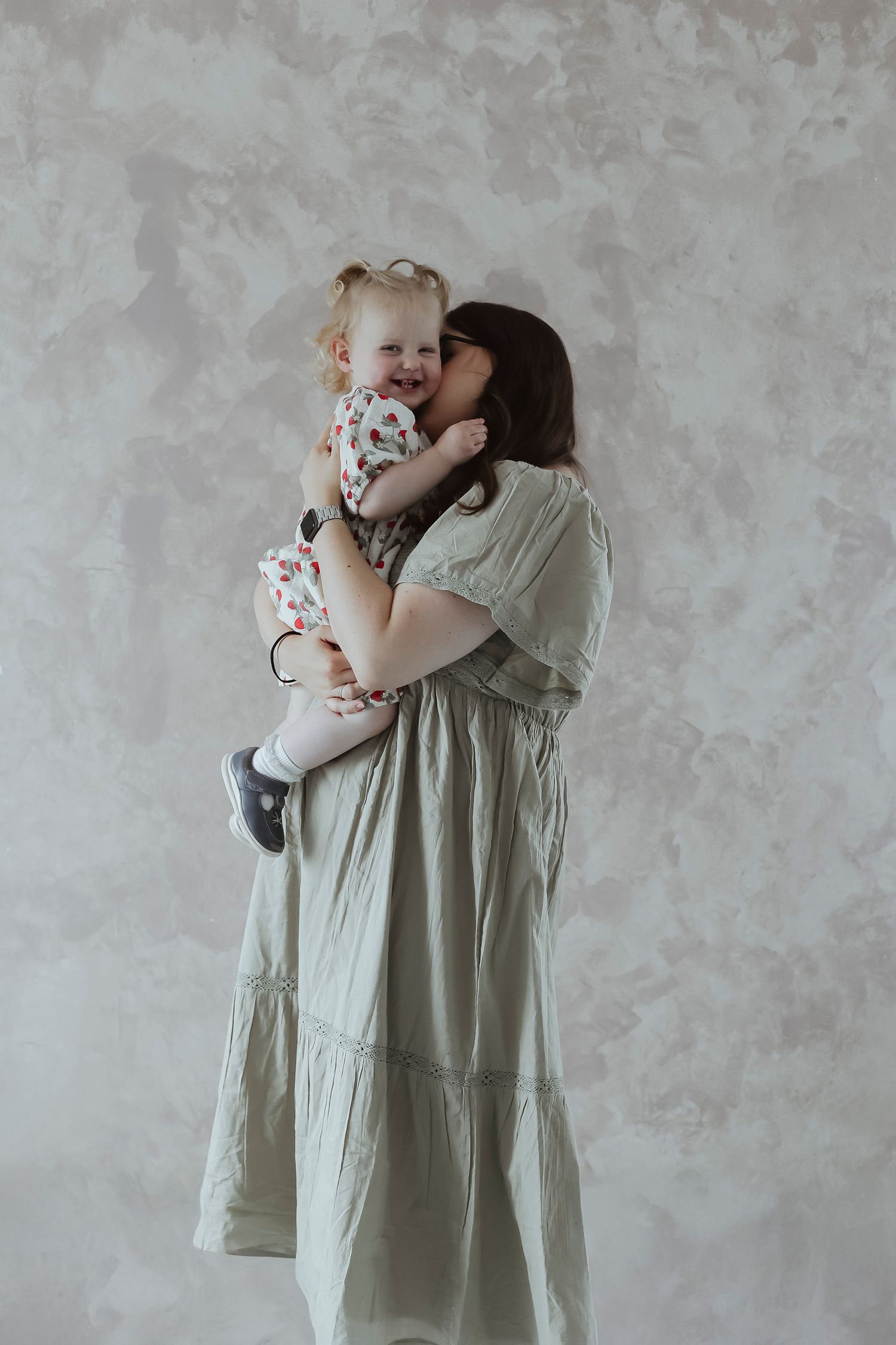 mother kissing her daughter in the studio