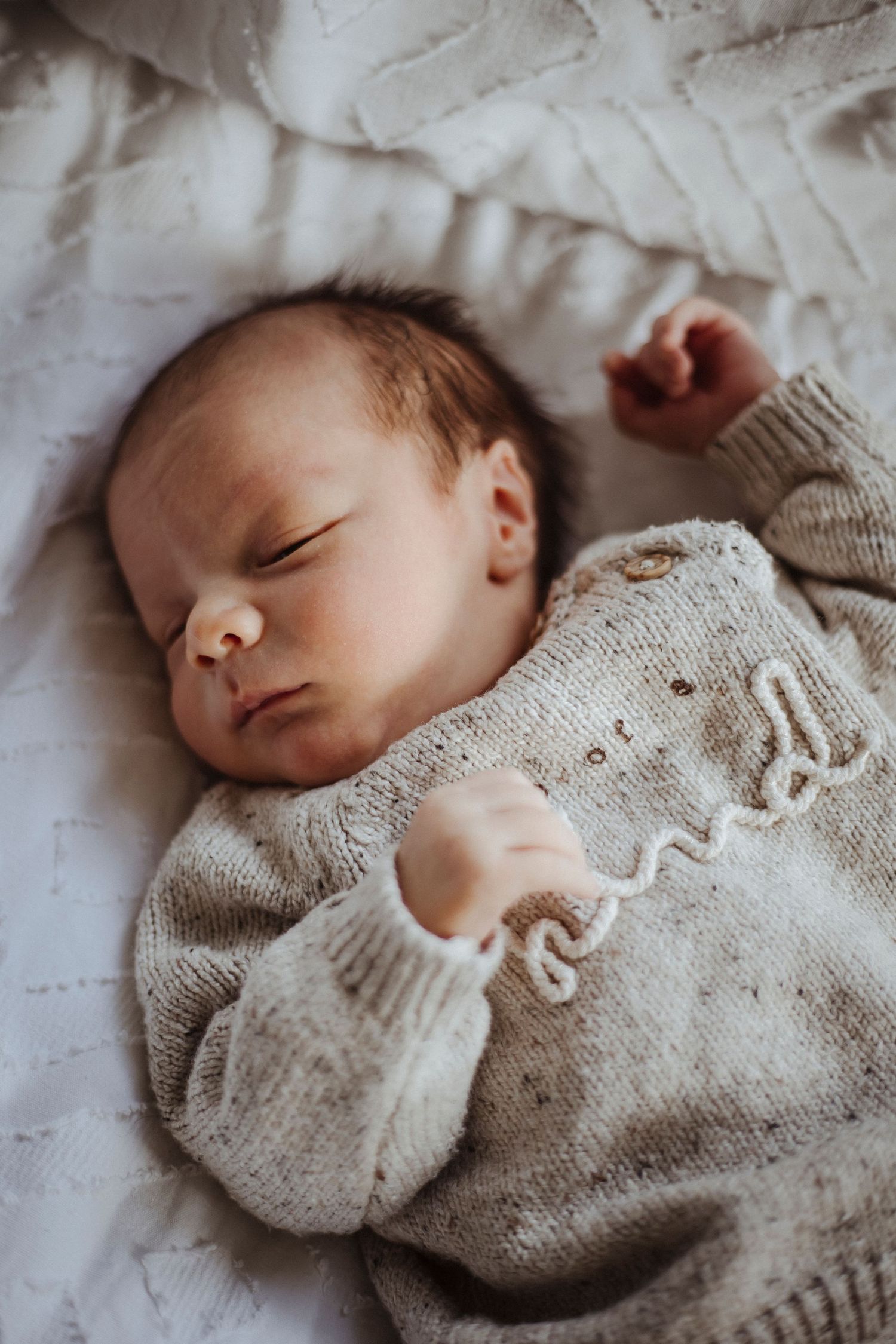 A peaceful newborn resting softly, wrapped in warmth and calm.