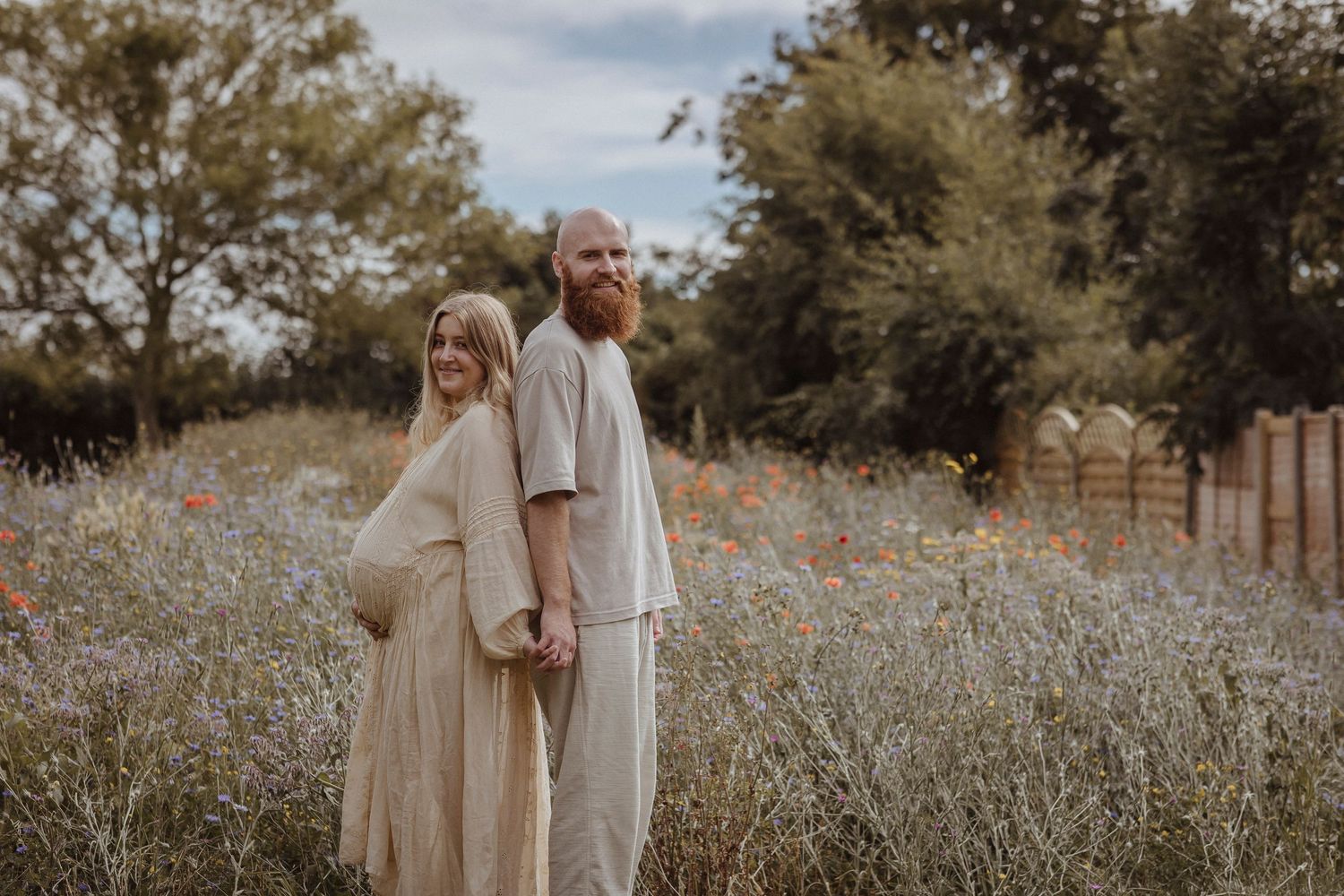 Hand in hand in a sea of wildflowers, waiting for their next beautiful chapter to begin.