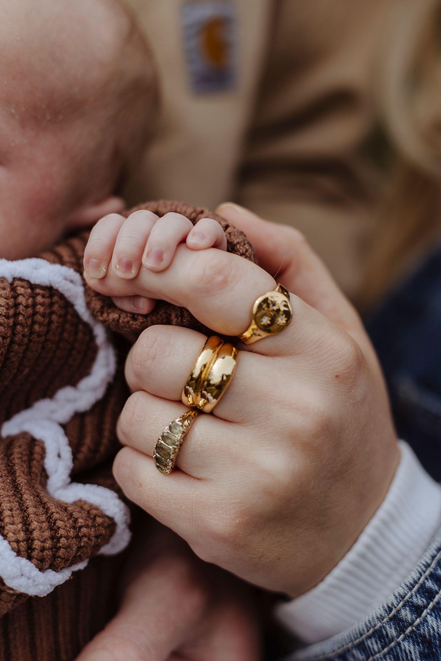 detail of baby hand holding ono mothers finger