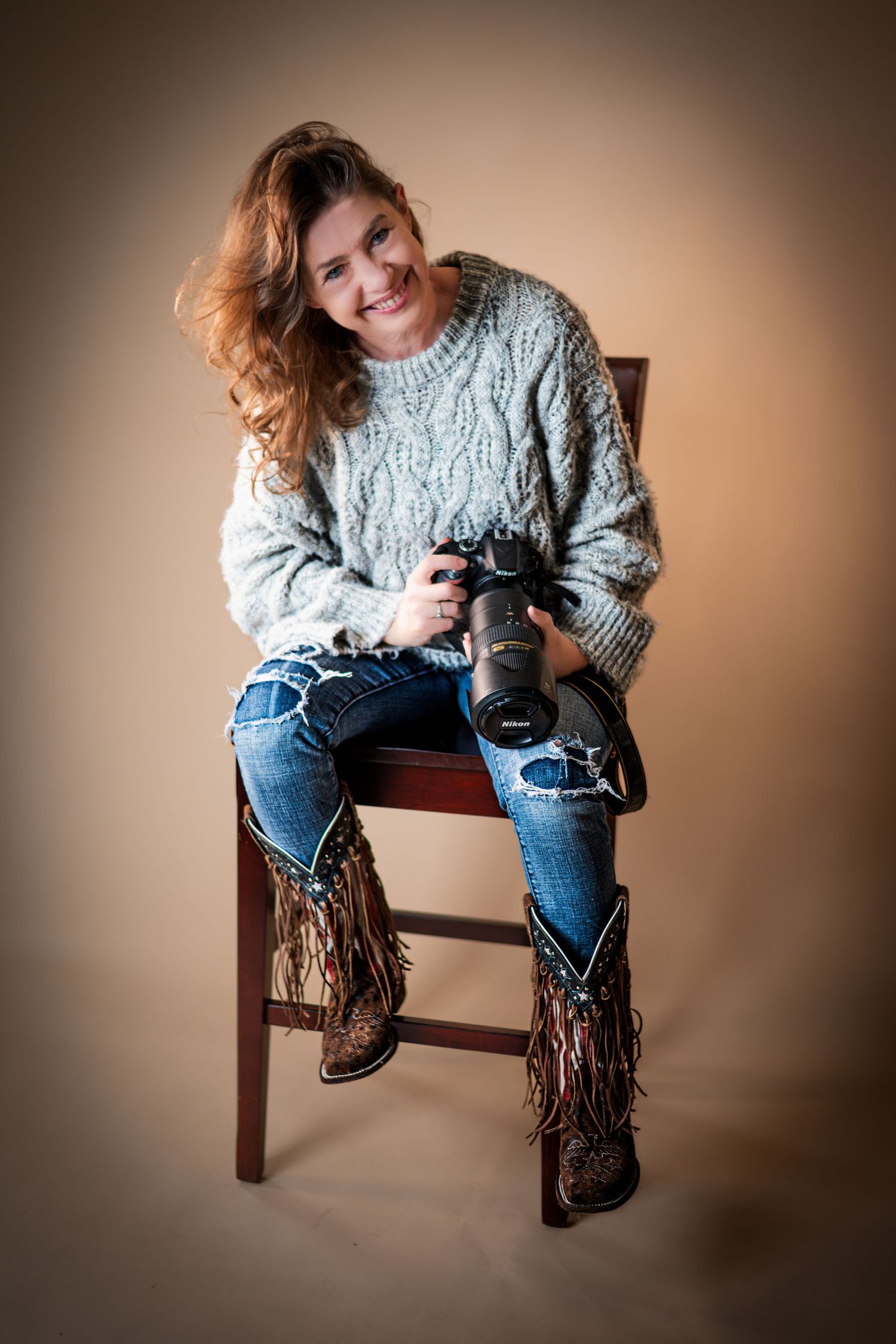 A series of photos showing someone sitting on a wooden chair wearing a cozy blue sweater, jeans and brown fringe boots.