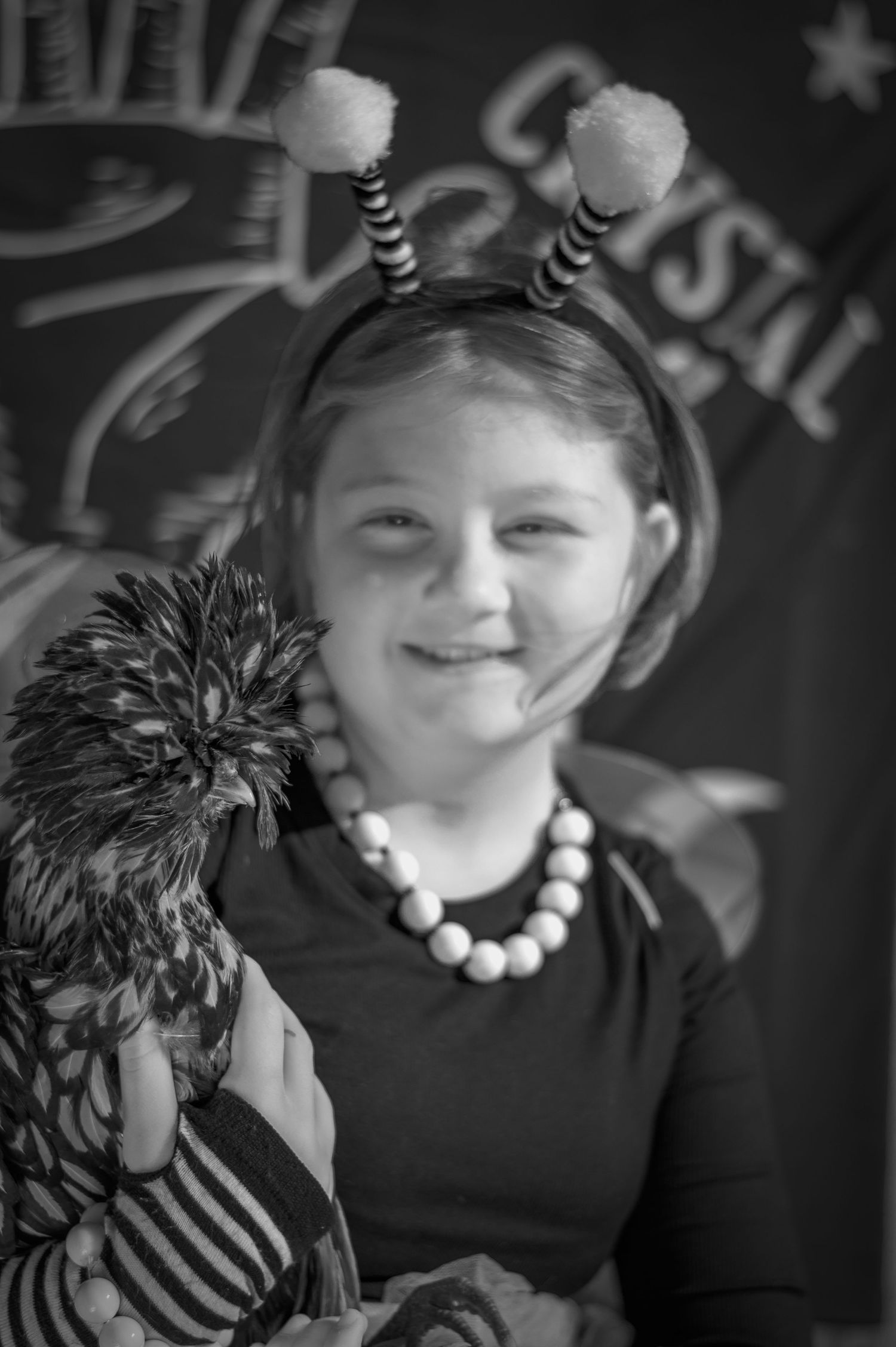 Close-up black and white portrait series showing someone wearing a dark top and beaded necklace.