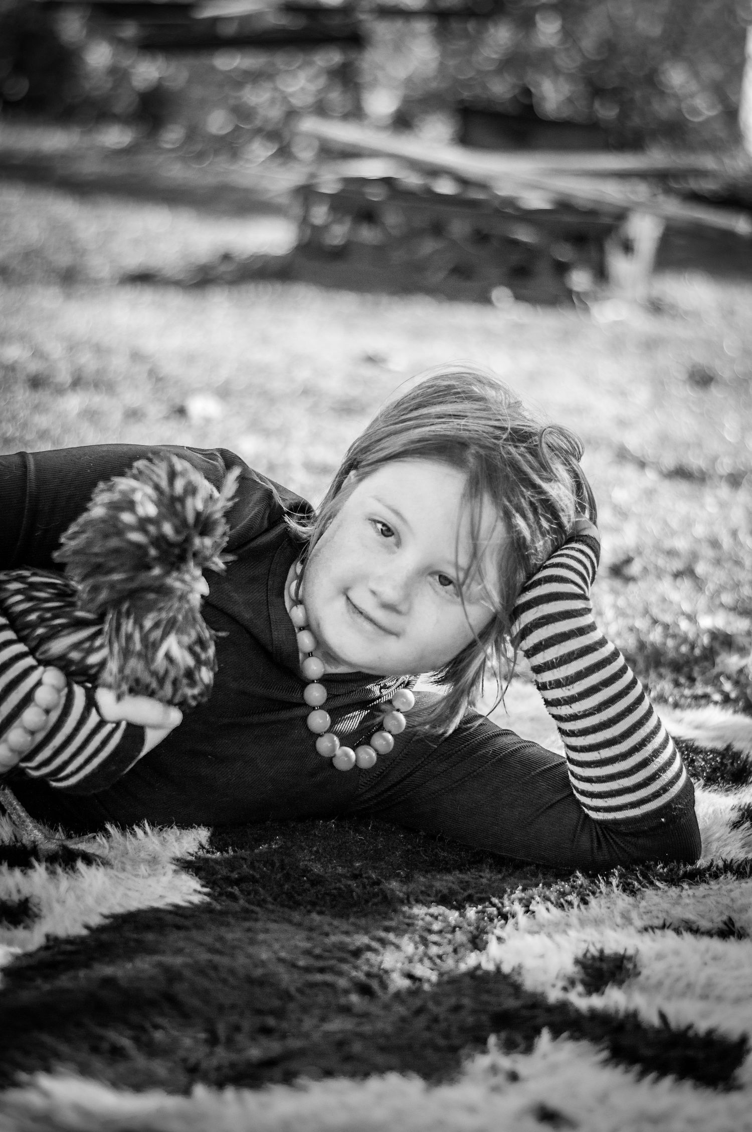 Black and white portrait on grass with striped sleeves and autumn leaves.