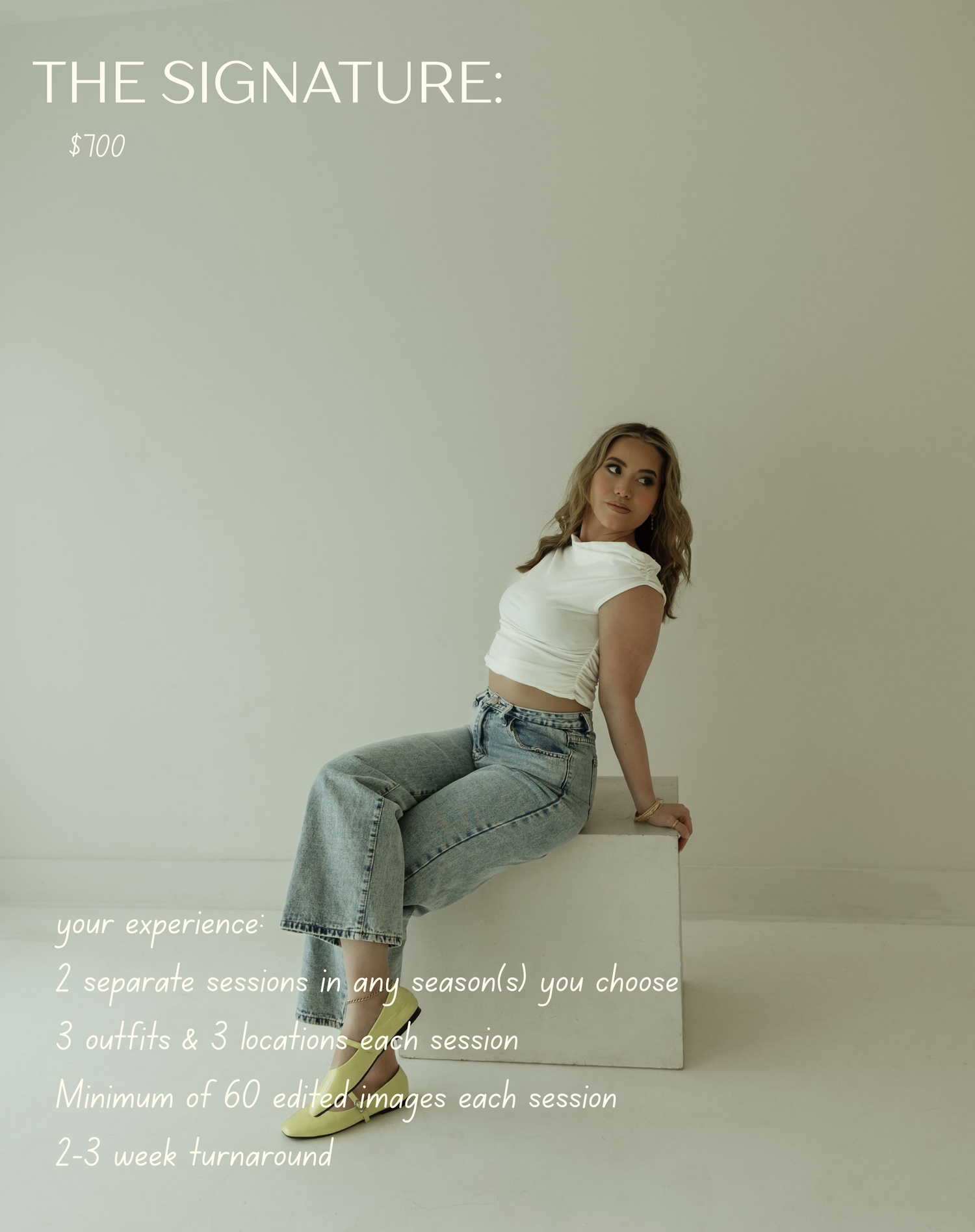 Woman in white crop top and jeans sits on white cube for The Signature photography package priced at $100.
