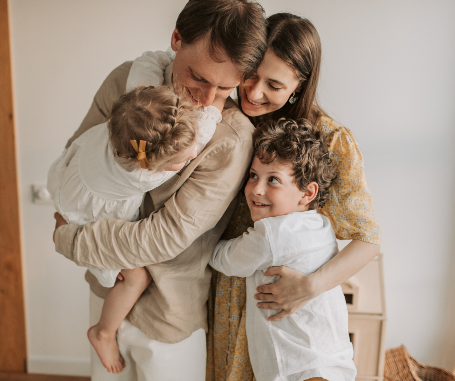 A collage of intimate family moments captured against a neutral backdrop in warm beige and white tones.