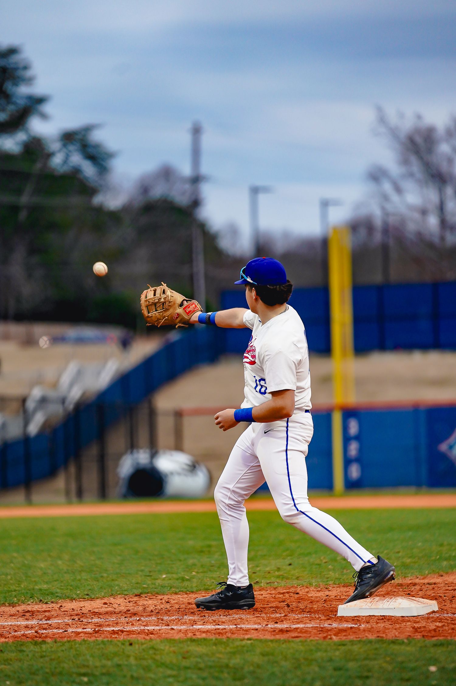 Baseball players demonstrate fielding positions on the infield dirt.