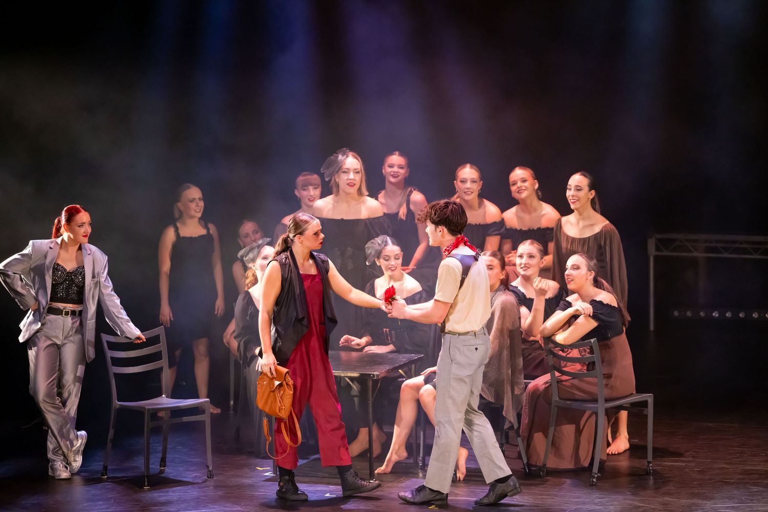 Theatrical dance performance with multiple performers in coordinated movements on stage.