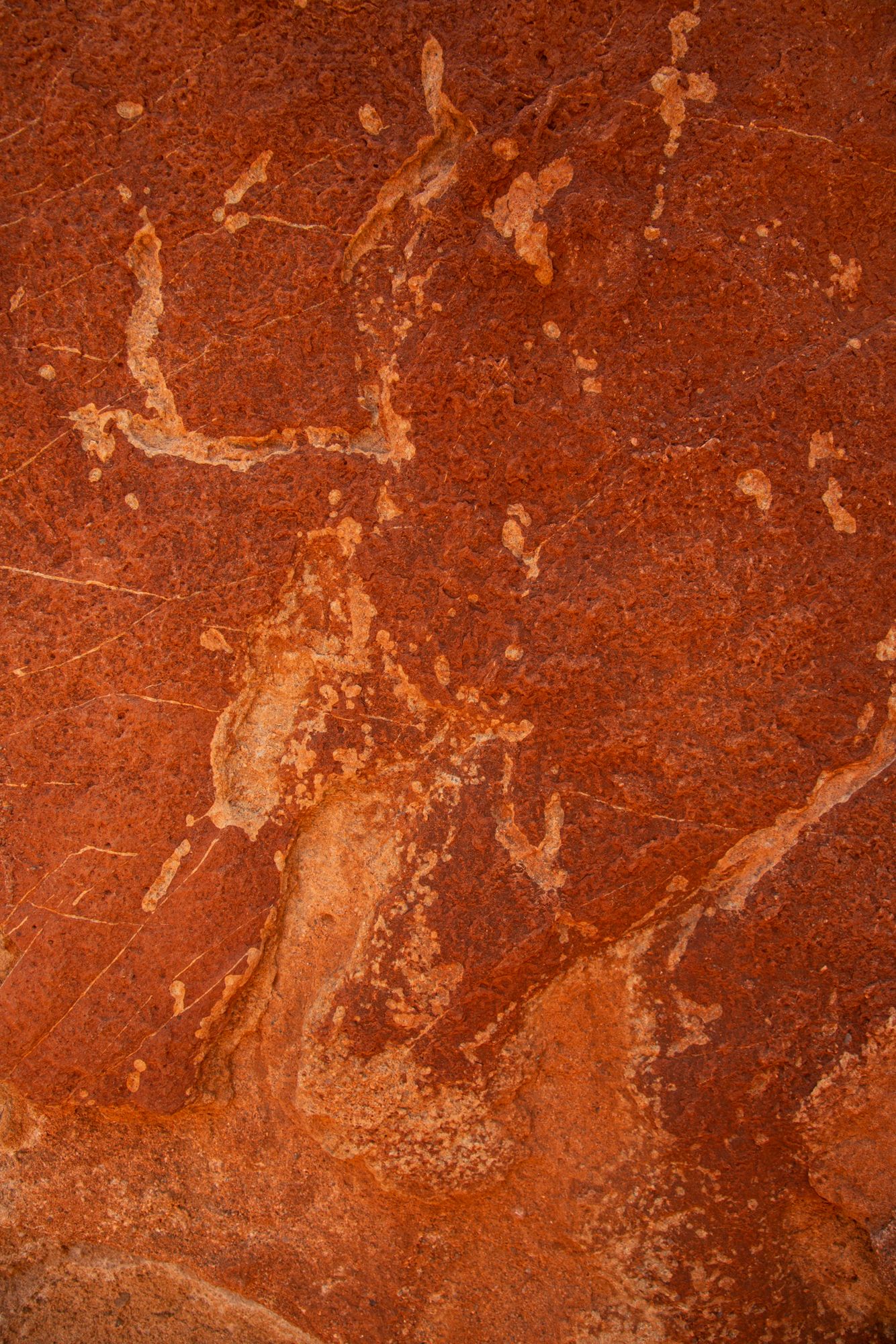 Close-up of rusty red metal surface with flaking paint and weathered textures creating abstract patterns.