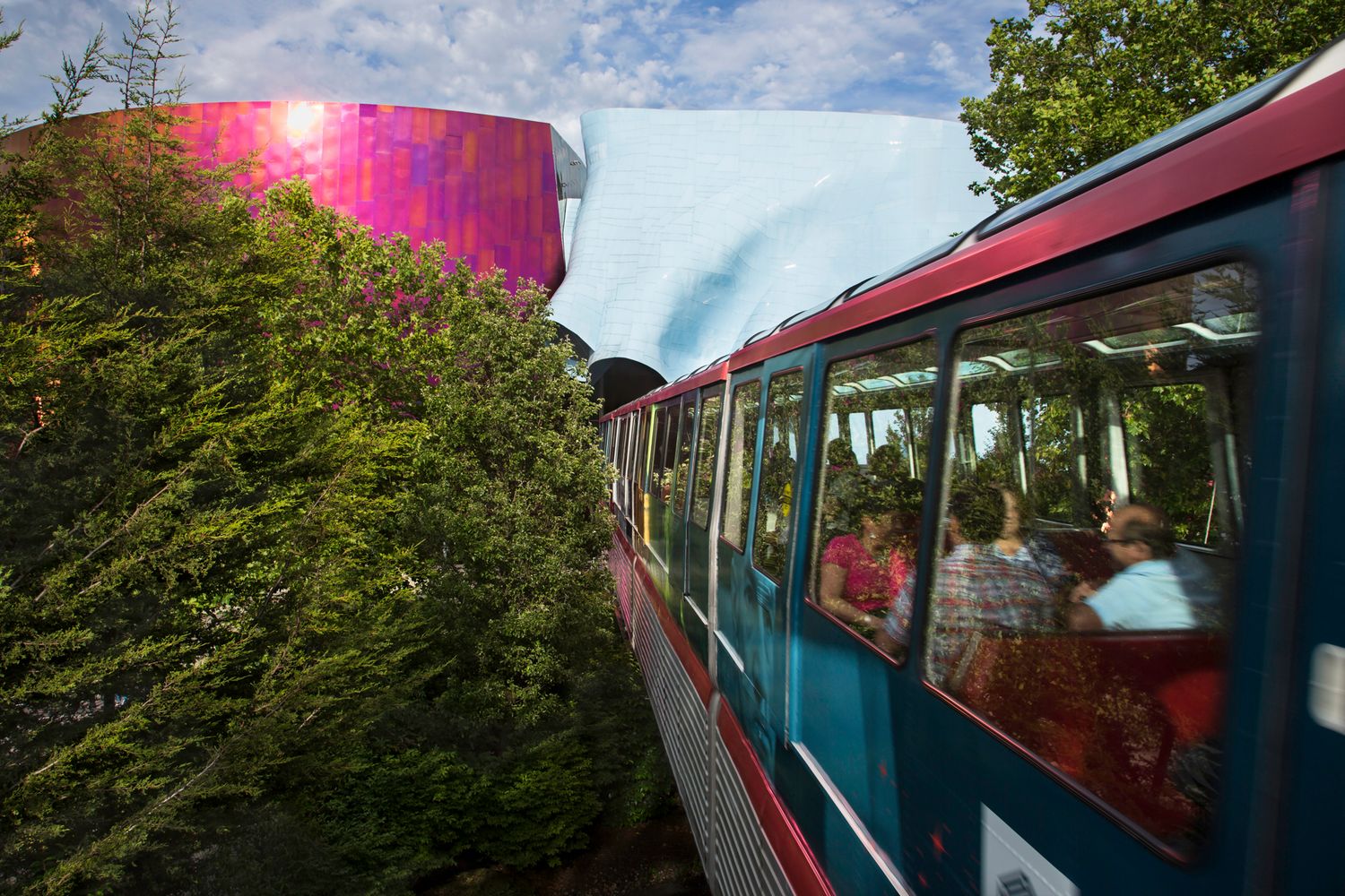 Double decker tour bus traveling through Vancouver's scenic streets with mountains in the background.