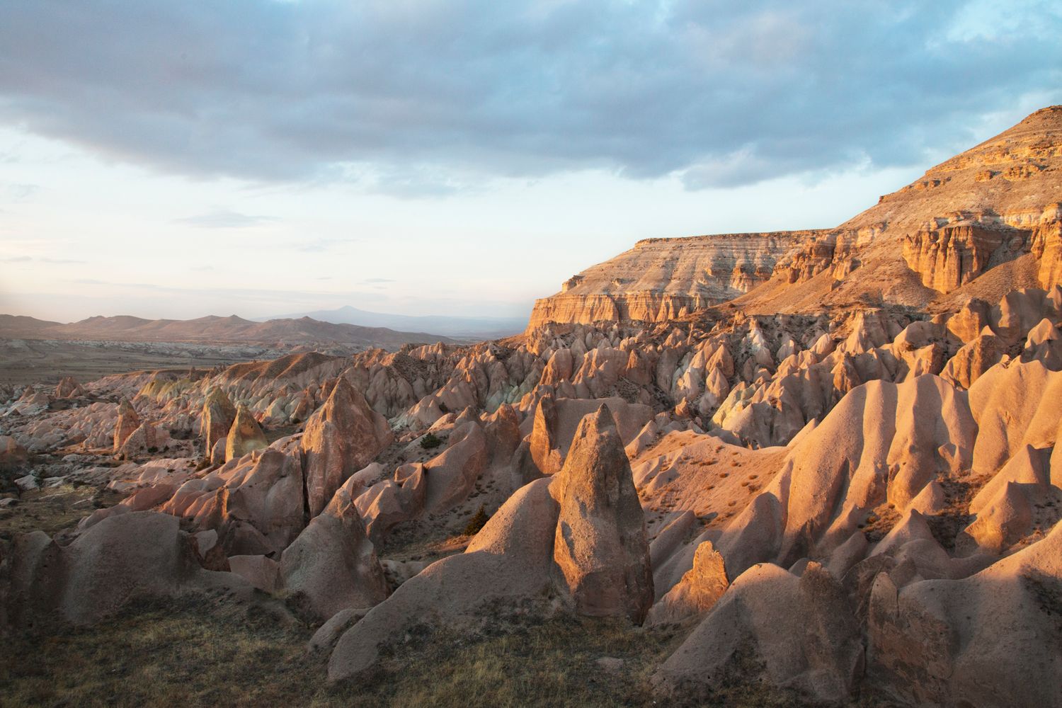 Sunlit rock formations create dramatic shadows across desert canyon landscape.