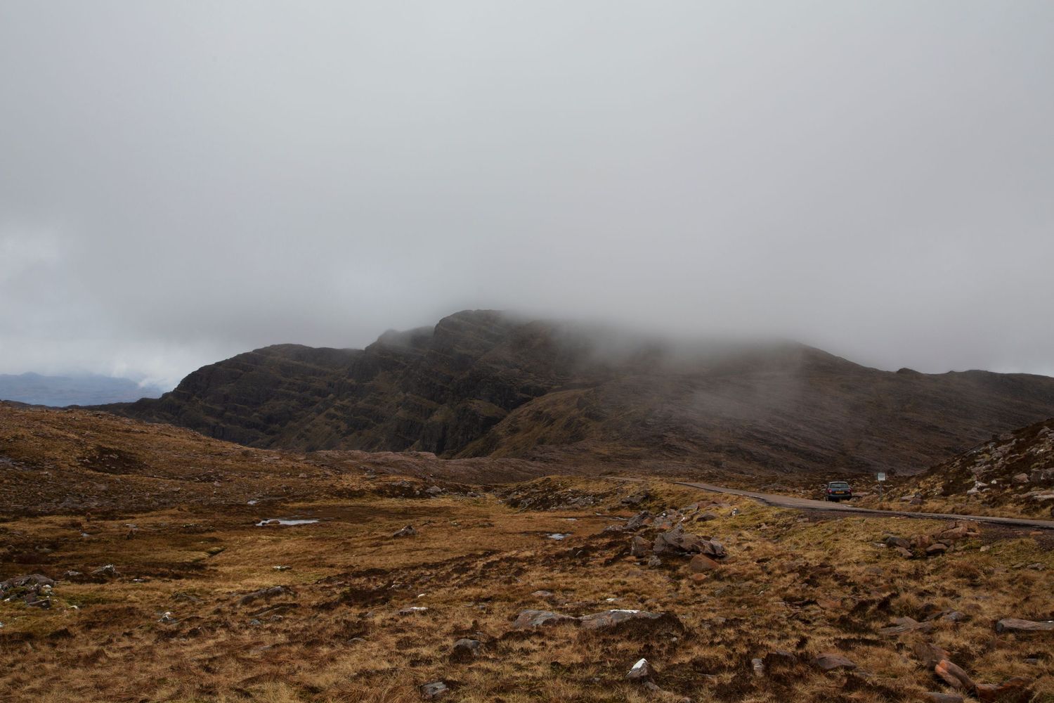 Misty mountain landscape panorama showing rugged terrain and cloudy skies.