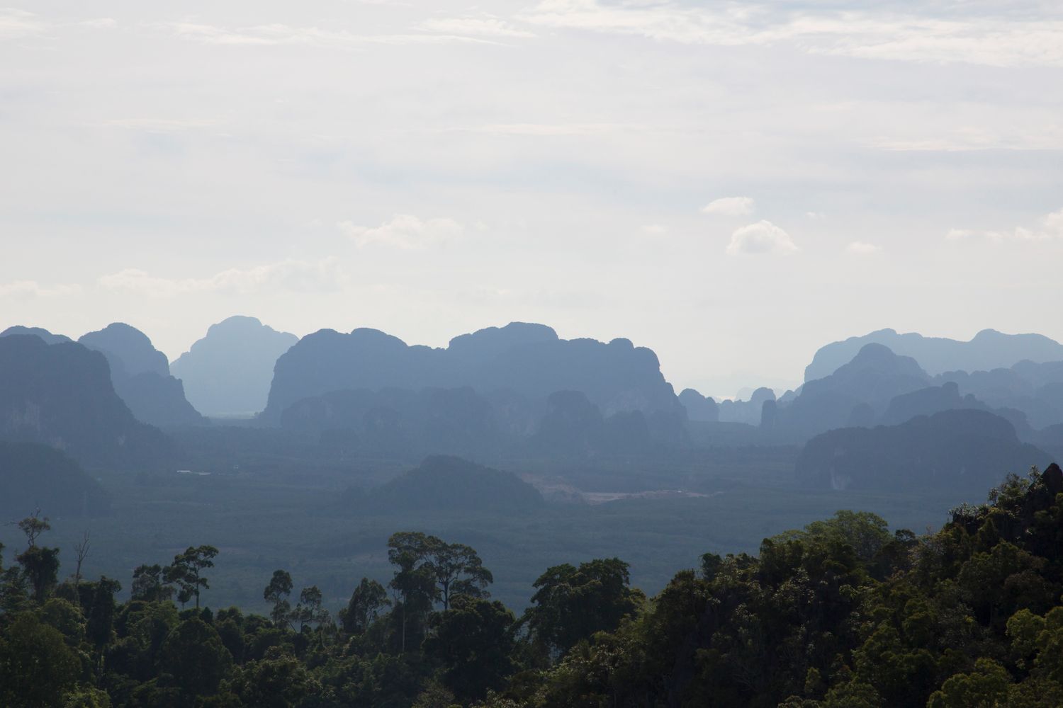 Silhouette of mountain ranges against a cloudy sky creating a dramatic landscape view.