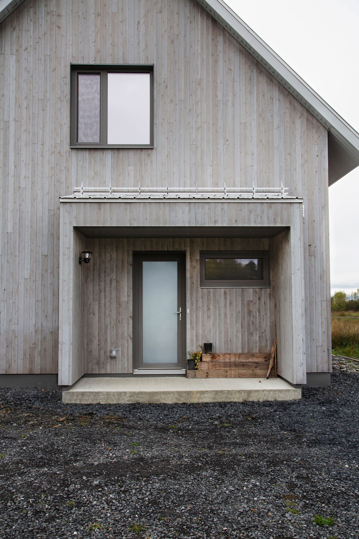 Contemporary wooden house with gray exterior and minimalist design features.