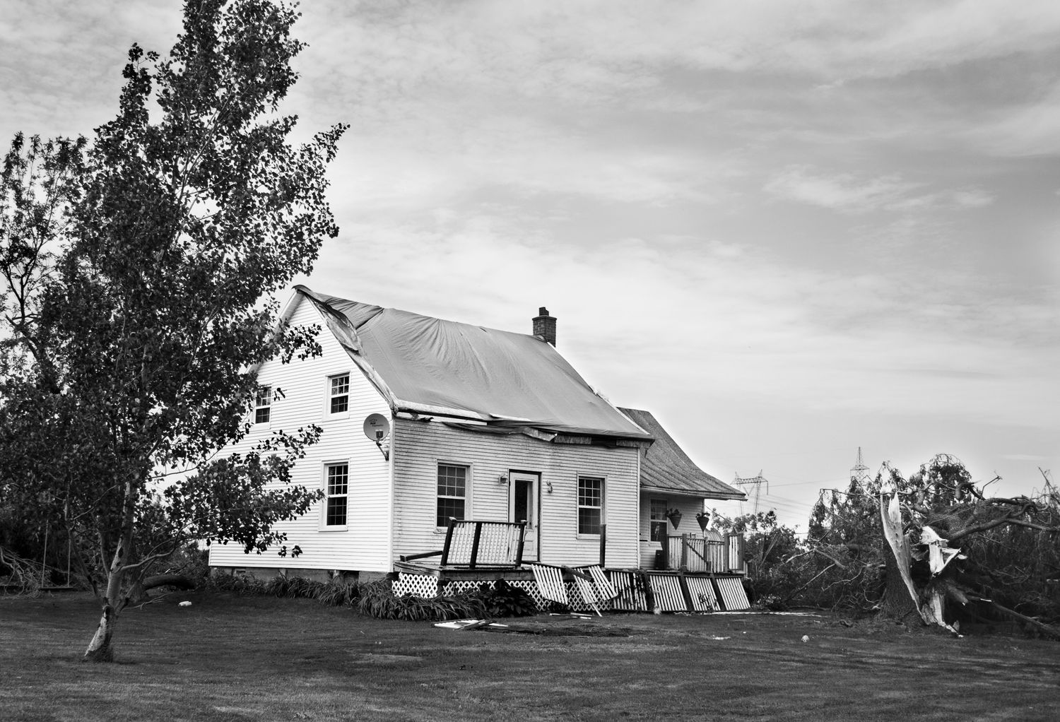 A black and white panoramic sequence showing a rural farmhouse and outbuildings against a cloudy sky.