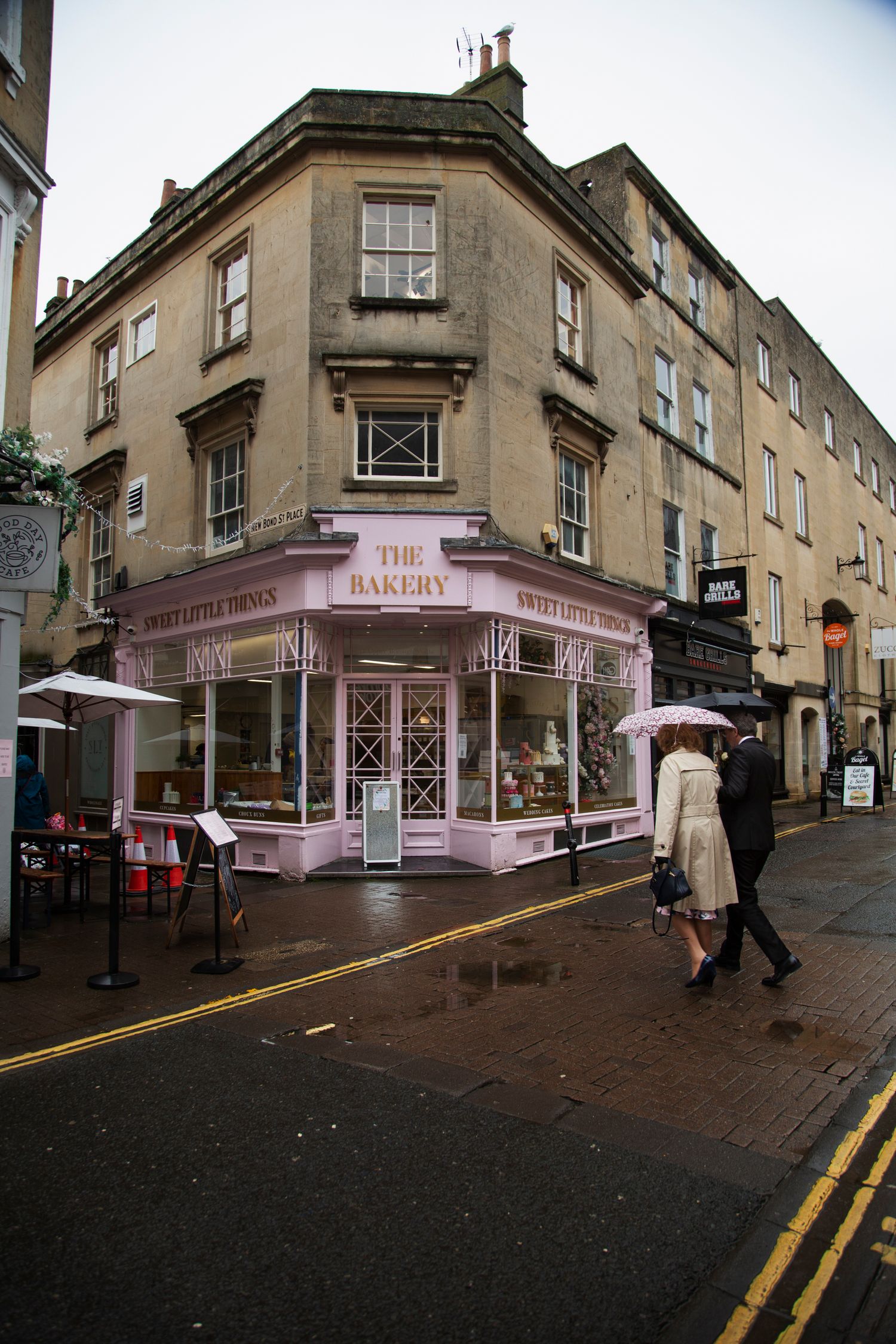 Pink corner shop storefront with traditional architecture along a cobblestone street.