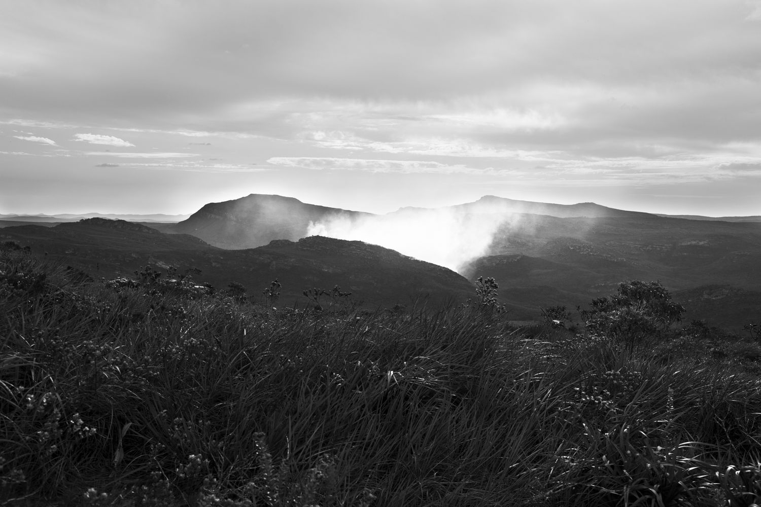 Dramatic mountain landscape with clouds rolling over distant peaks.