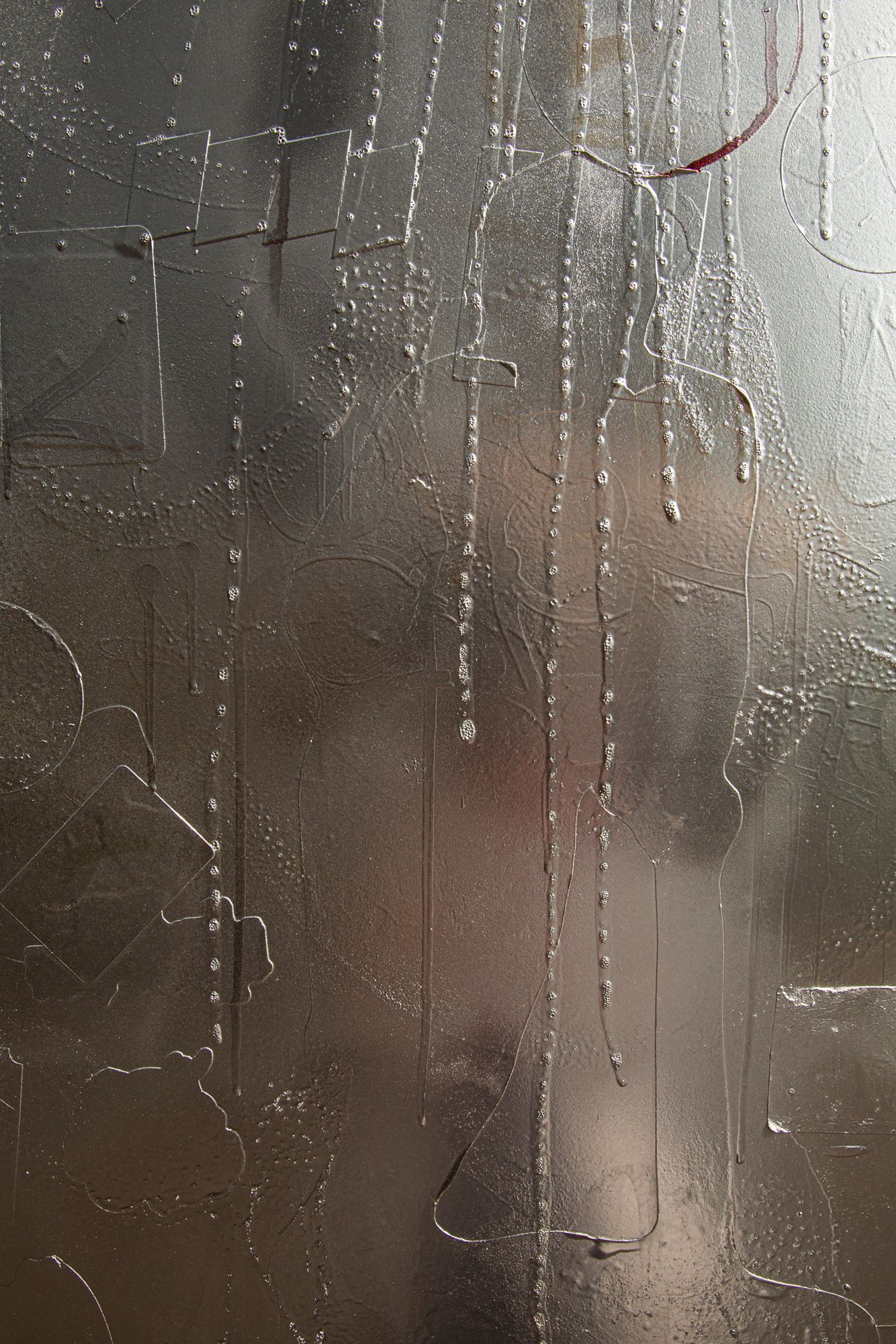 Water droplets and condensation create abstract patterns on a foggy glass window surface.