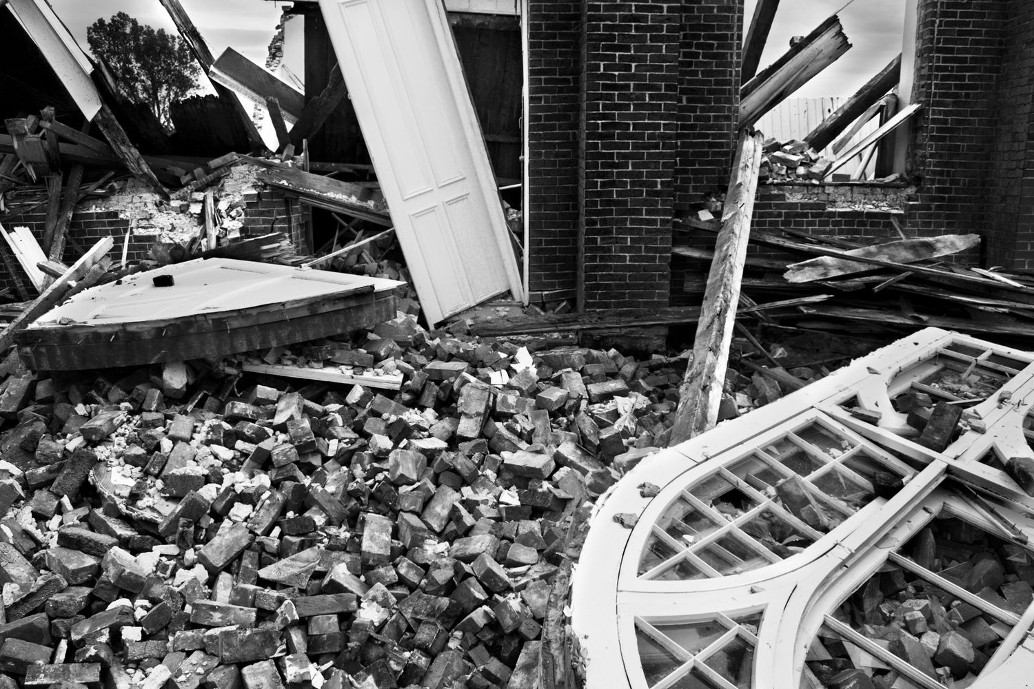 Debris and wreckage scattered across a landscape showing extensive storm or tornado damage to buildings and structures.