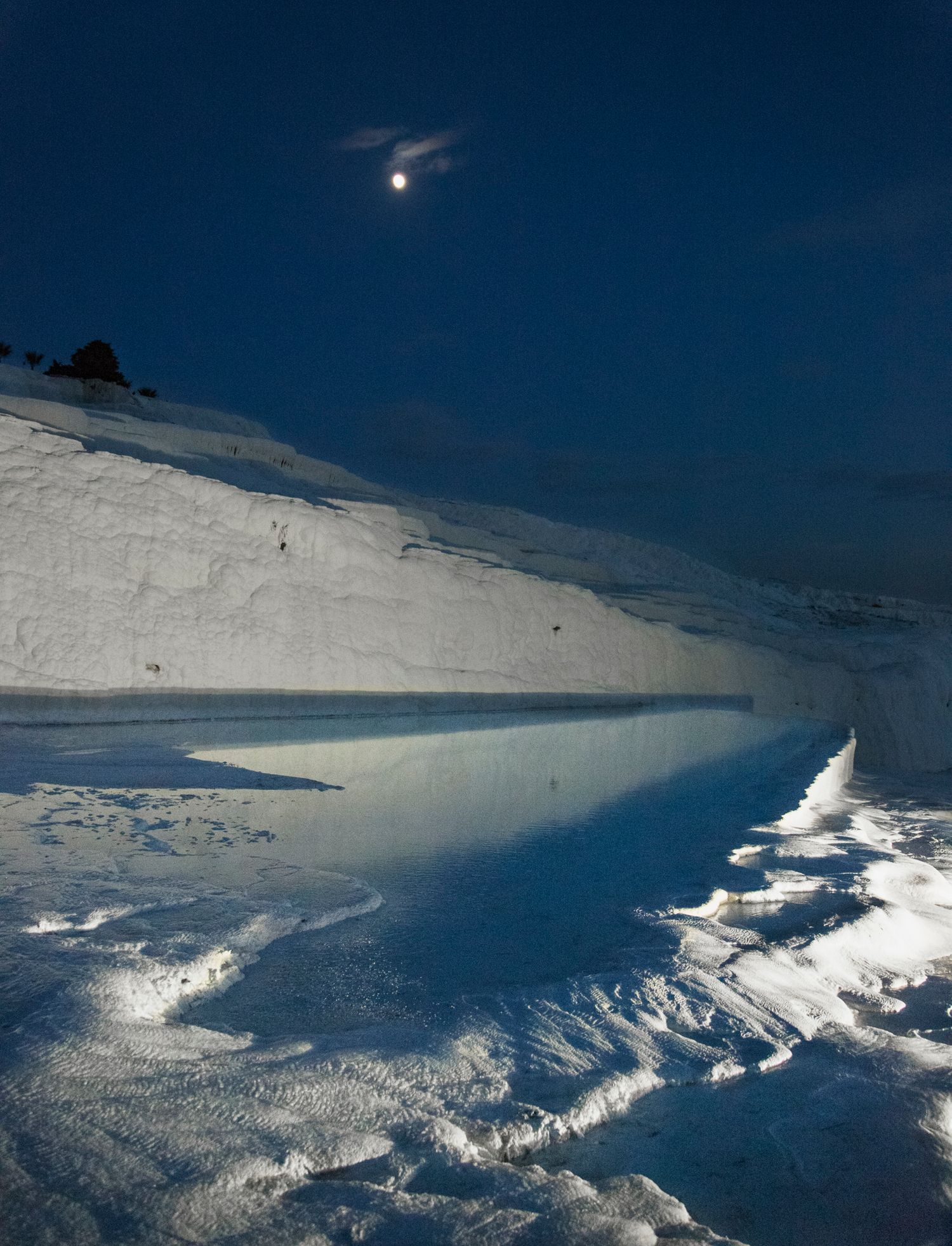 Snow-covered mountain slopes under bright blue sky with dramatic shadows across pristine winter landscape.