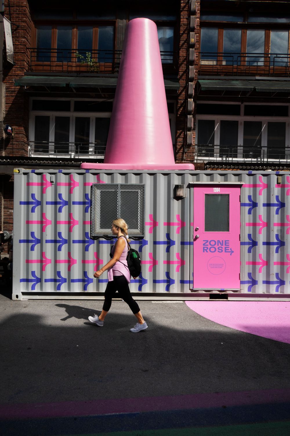 Pink architectural elements against a modern building facade creating geometric patterns and shadows.