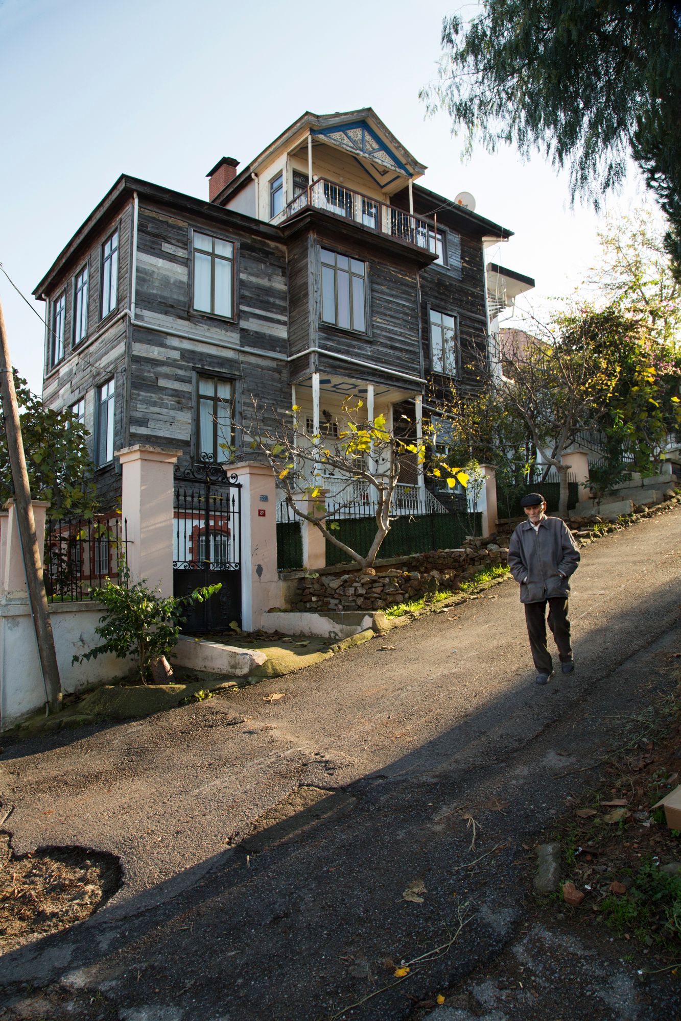 Traditional wooden houses on a steep hillside street in an old neighborhood.