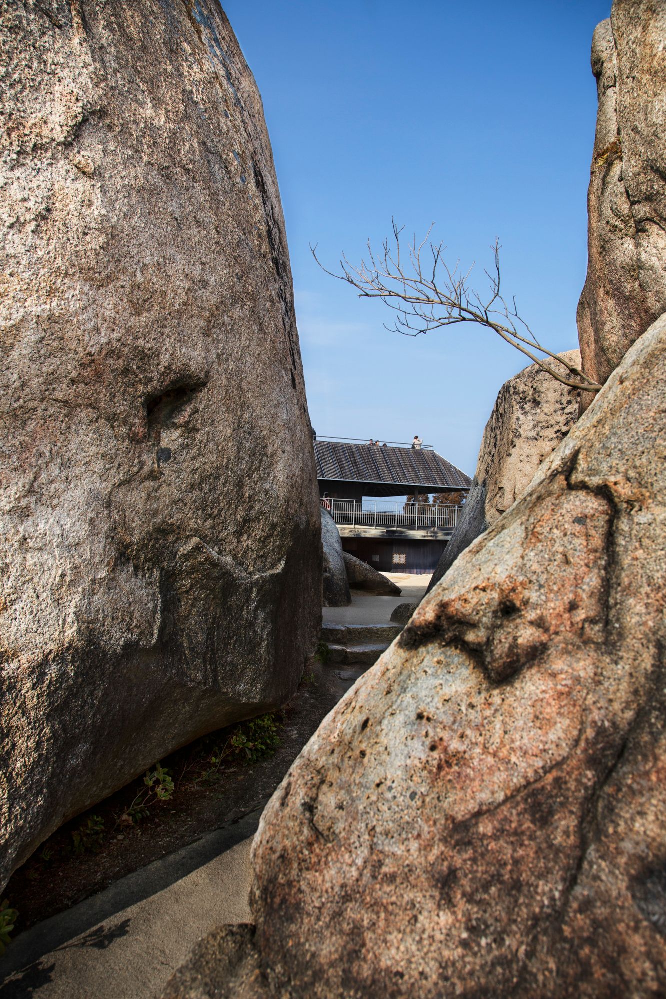 Close-up view of weathered stone wall textures and surfaces against blue sky.