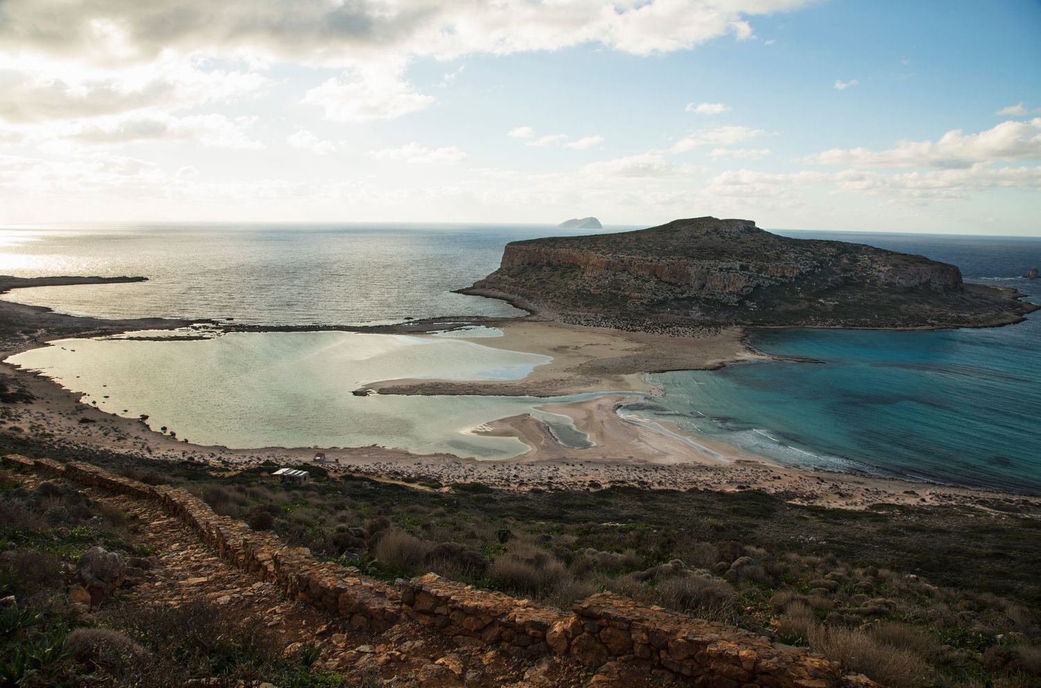 Aerial view of dramatic coastal cliffs and sandy beaches along turquoise waters.