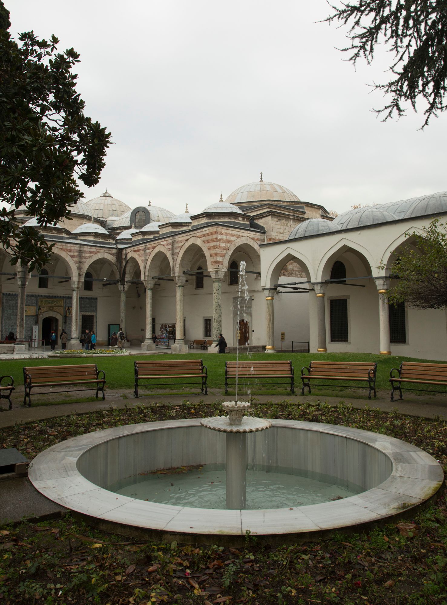 Historic Ottoman-style mosque courtyard with arched walkways and central fountain.