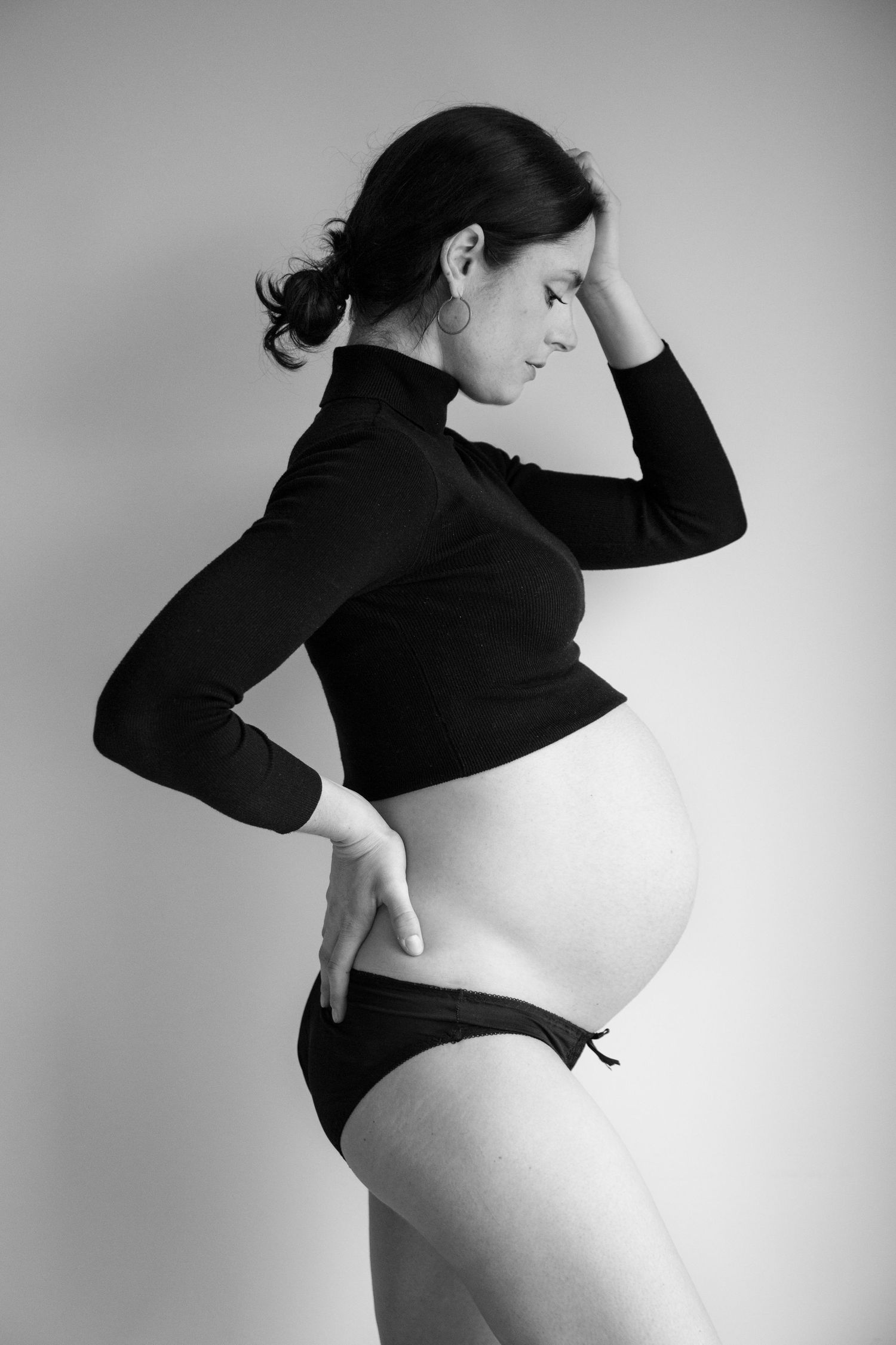 Artistic black and white pregnancy silhouette series showcasing maternal form.