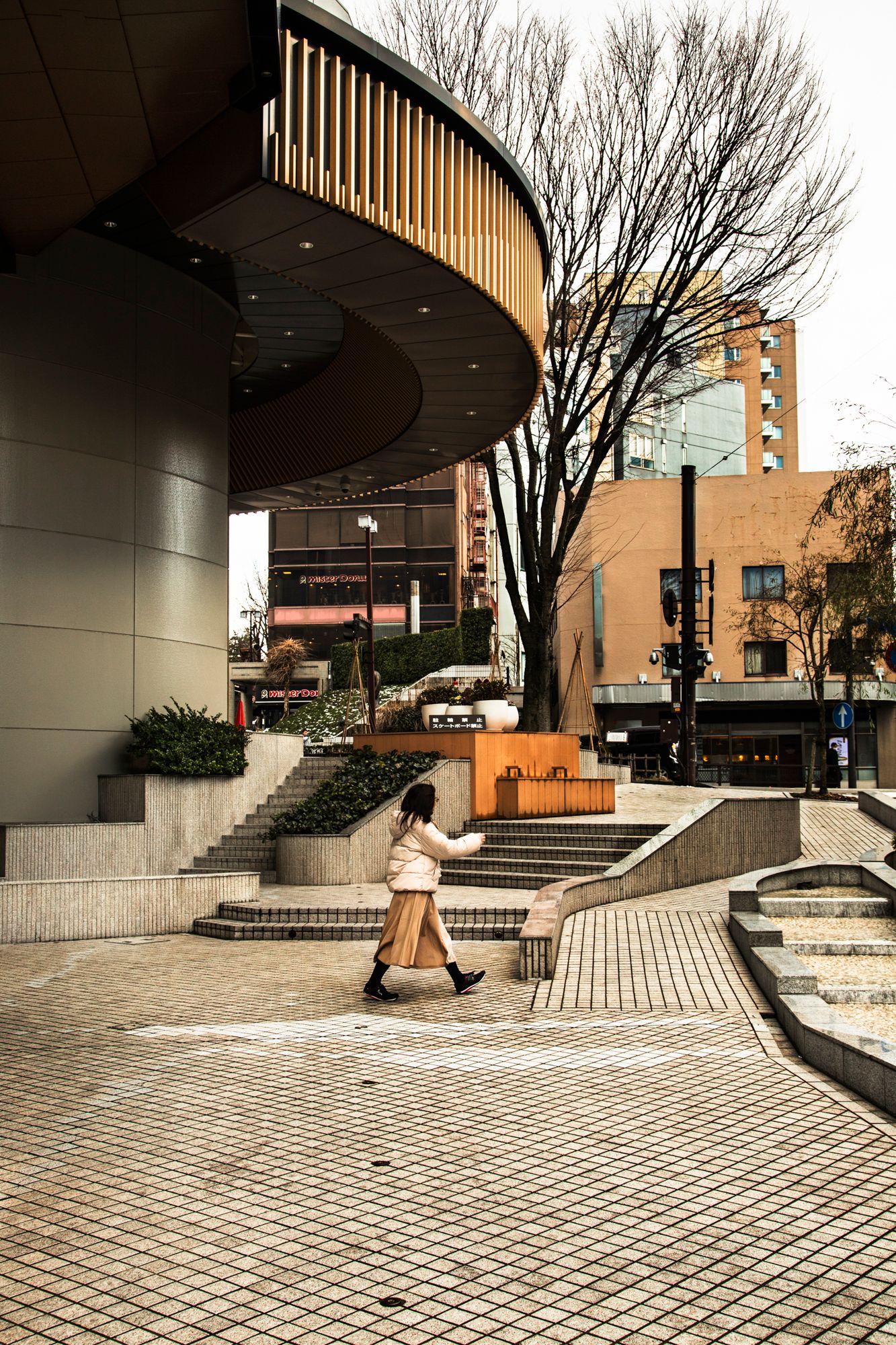 Modern curved architecture with brick pavers and geometric urban design.